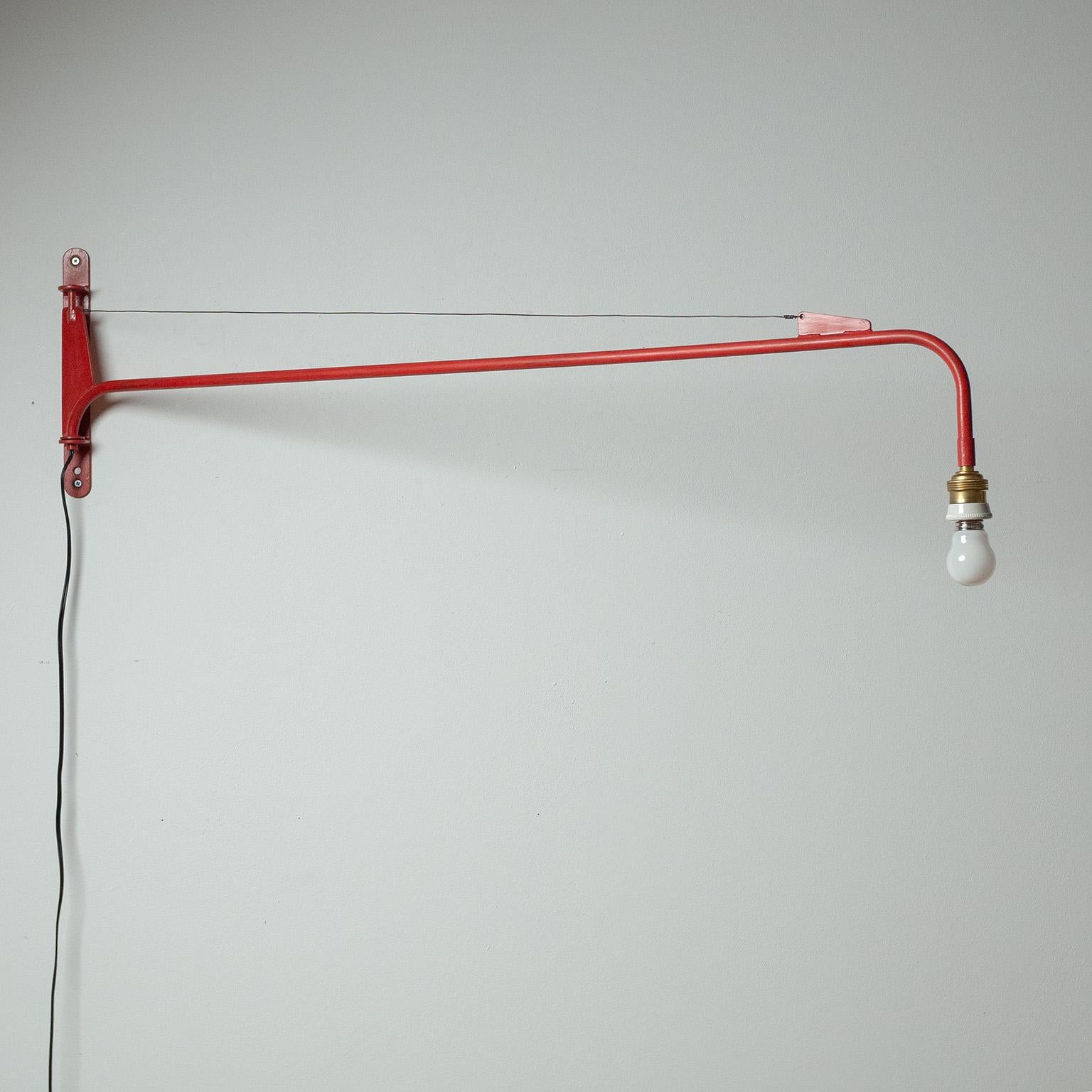Klassische französische Potenz-Schwenkleuchte von Jean Prouvé aus den 1950er Jahren. Rot lackiertes Eisen und ein Schwenkmechanismus, der eine mühelose 180º-Bewegung ermöglicht. Das Design und die Abmessungen der Rückenplatte und anderer Elemente
