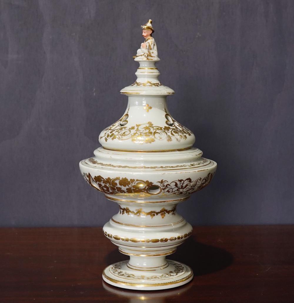 Unusual French porcelain pot pourri jar with celadon ground, pierced with clubs, diamonds and circles, and with gilt scrolls, the knop formed as a seated oriental figure,

circa 1870.