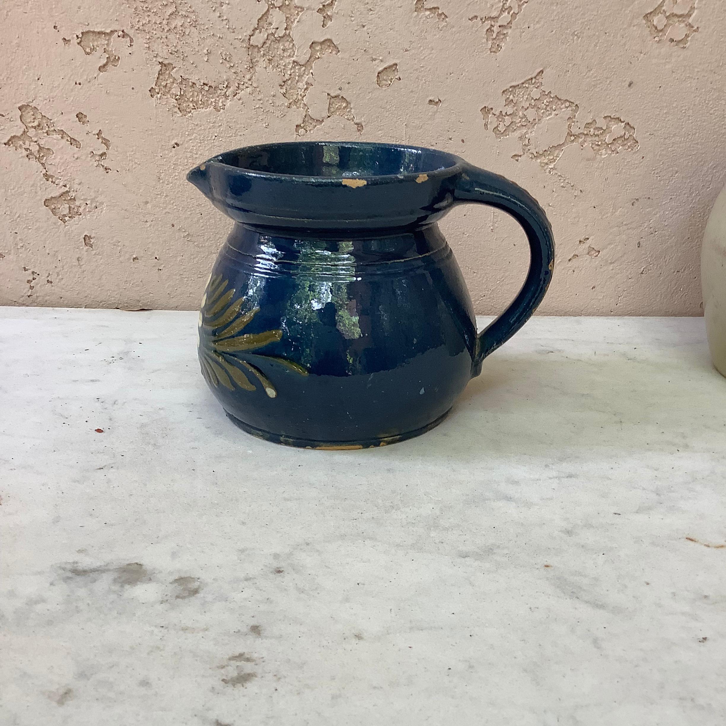 19th century blue ceramic pitcher with white flower from Savoie, France. No maker's mark. Minor wear.