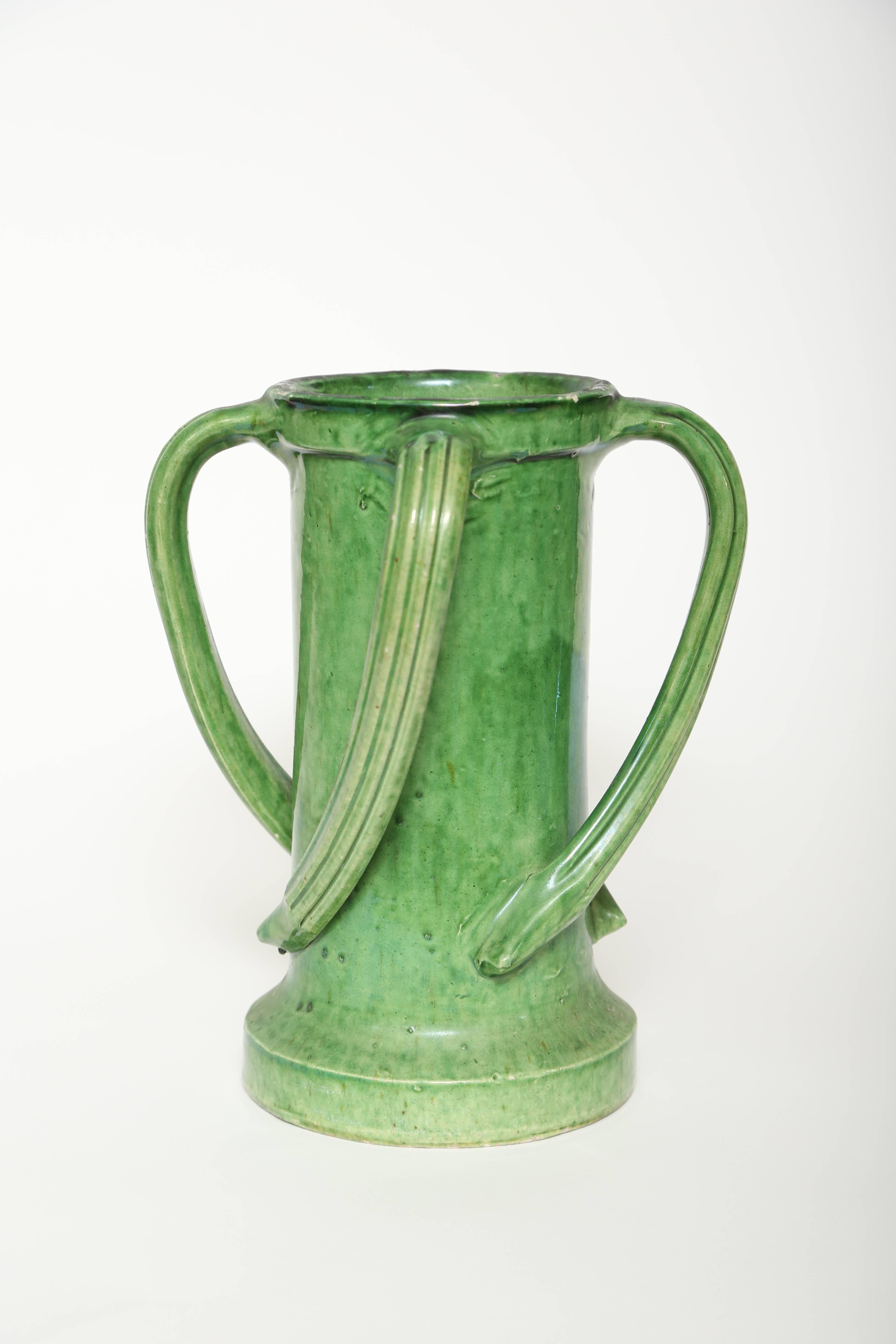 Very unusual antique four handled French green glazed ceramic vase. The handles are applied at the top and gently swirl counter clockwise to the base.
There are several areas where the glaze has raised, however, typical of pottery with this age.
