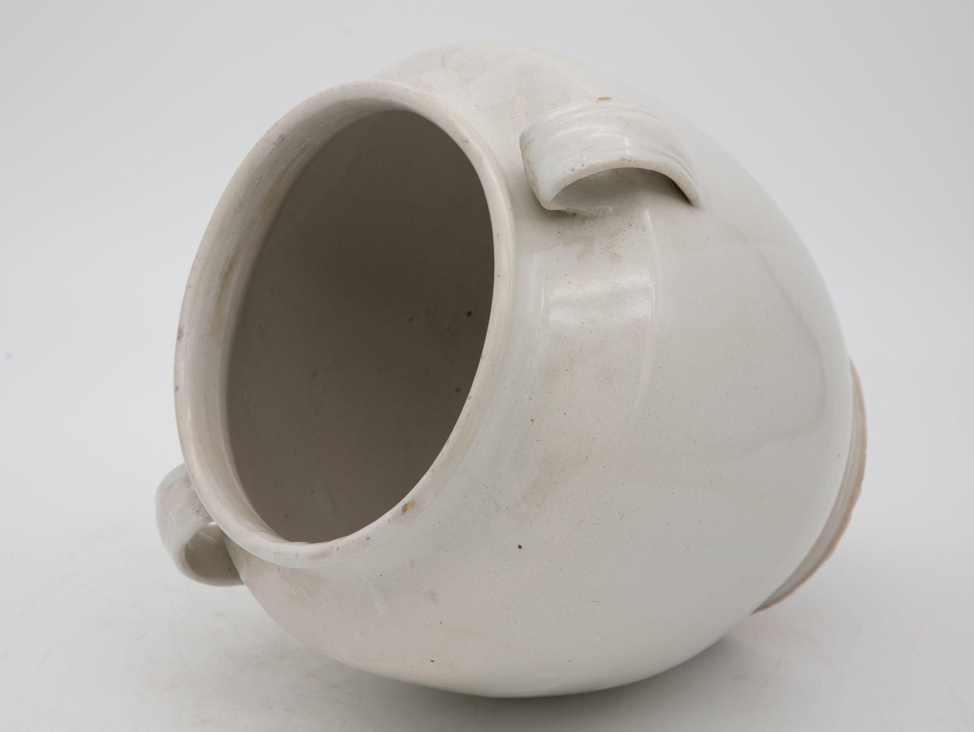 A 20th-century white pottery urn or confit pot. Wear consistent with age and use.