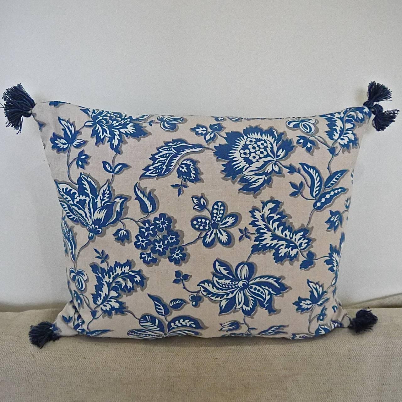 French cotton cushion printed with stylized fresh blue and white flowers and leaves on a soft off-white ground, circa 1930-1940s. Backed in the same design with vintage French blue cotton tassels on each corner. Slip-stitched closed with a duck