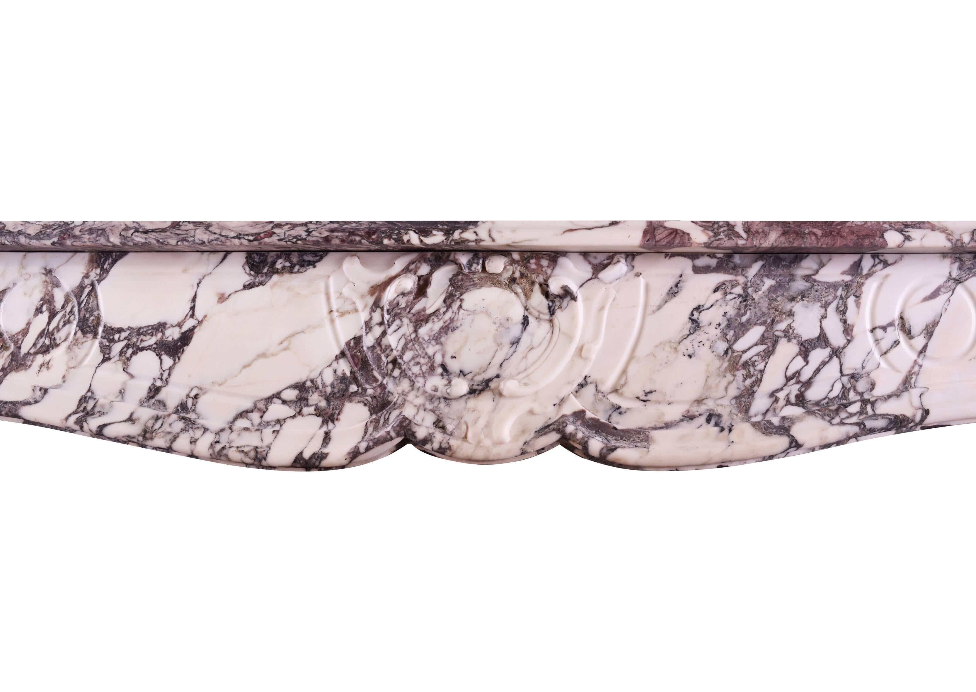 Cheminée provençale française de style Louis XV en marbre Violette. Les jambages sculptés et façonnés sont surmontés d'une frise lambrissée avec un cartouche sculpté au centre. Etagère moulurée au-dessus. Marbre Breccia de bonne qualité.

Mesures :