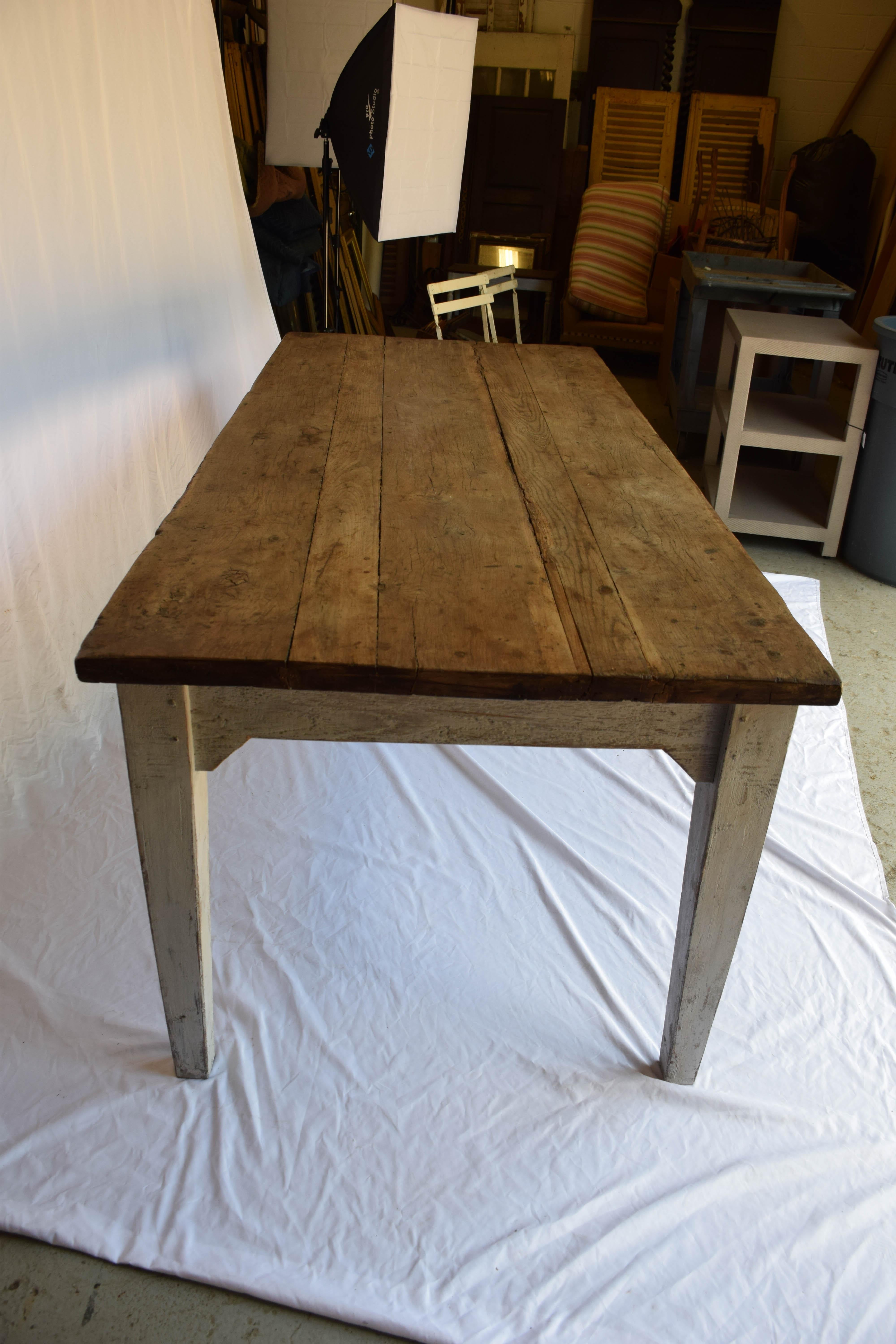 A fabulous rustic 19th century French Provencial farmhouse table. The top, with a wonderfully aged wood patina sits on a painted base with nicely tapered legs and a shaped apron. Would work well in many settings.