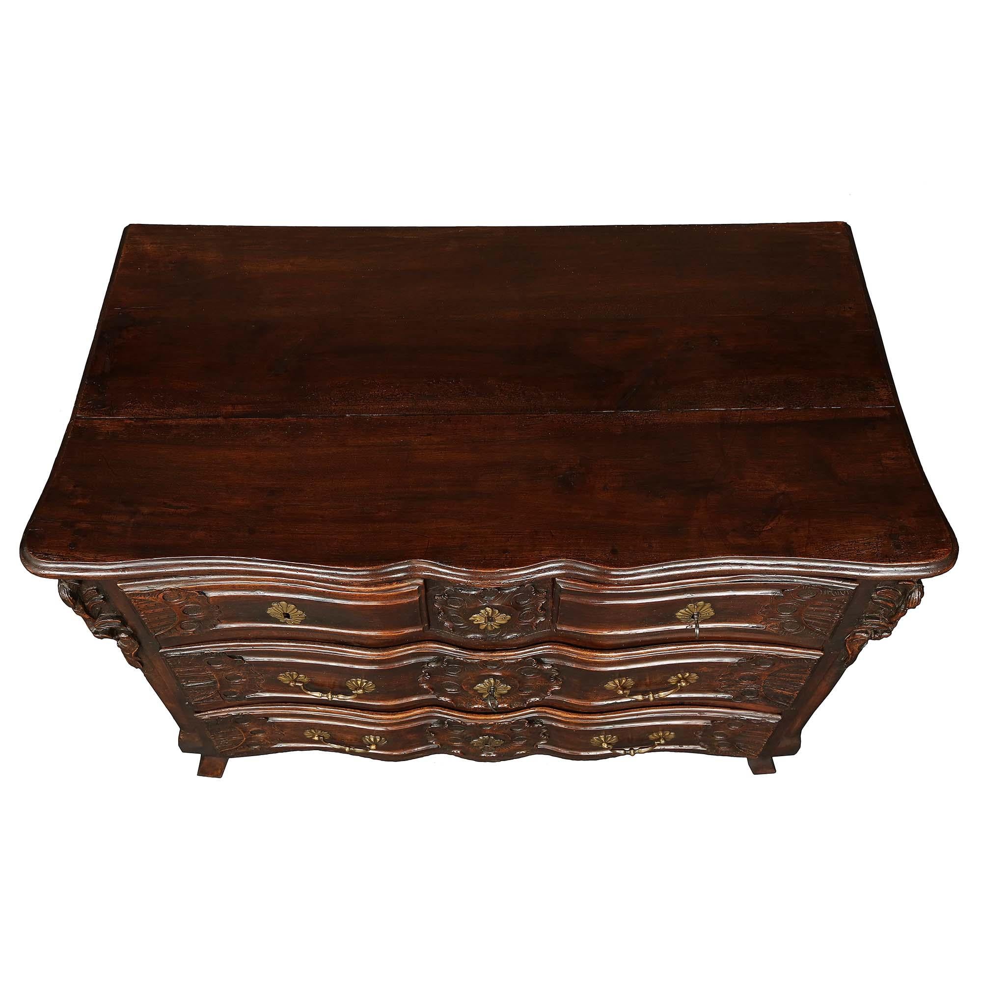 A very handsome French Provincial 18th century Louis XV period walnut commode. The chest is raised on front curved feet and straight back feet with paneled sides. Finely carved drawers, two at the top and two wider ones below, all have large