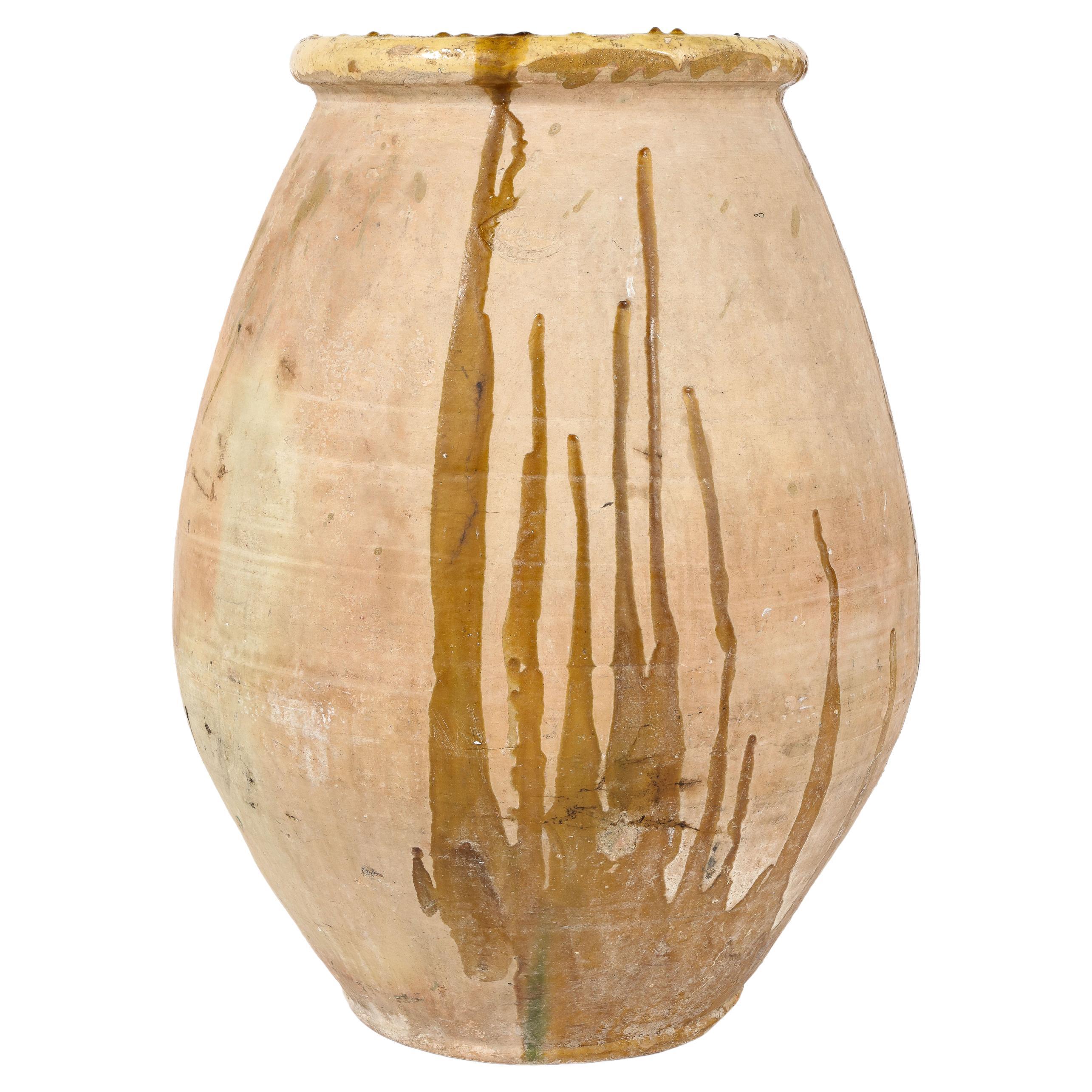 A grand scale French provincial terracotta Biot Jar produced in the Biot region of southern France. With its original yellow glazed rim and traces of ochre colored glaze dripping throughout, creating a beautiful and unique abstract design.  These