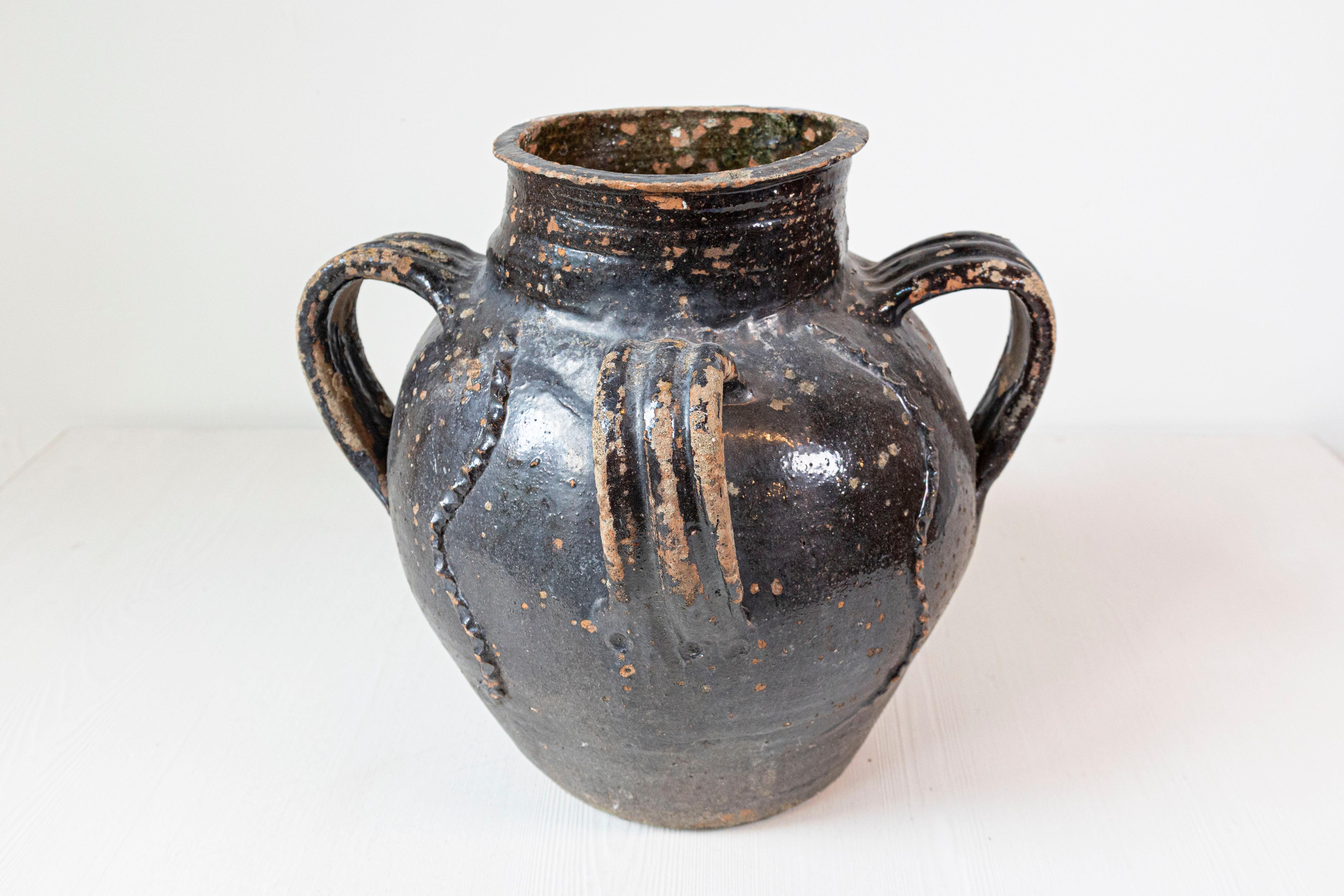 Verseuse en poterie vernissée de style provincial français, datant du 19e siècle, avec un seul bec, trois poignées et un grand caractère rustique. Créée dans le sud de la France au cours du XIXe siècle, cette cruche en poterie attire notre attention