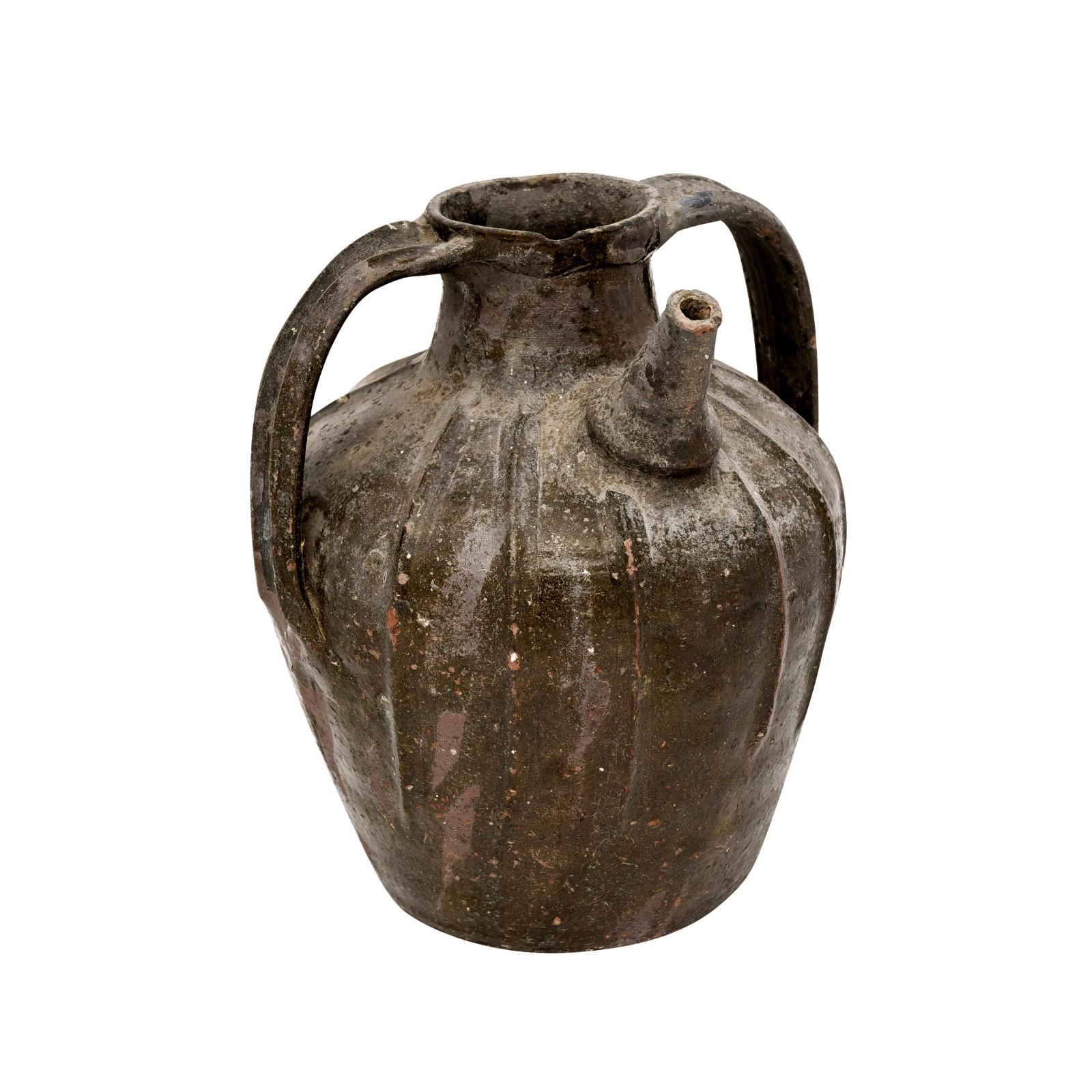 A French Provincial glazed pottery pouring jug from the 19th century, with single spout, two handles and great rustic character. Created in southern France during the 19th century, this pottery jug attracts our attention with its interesting