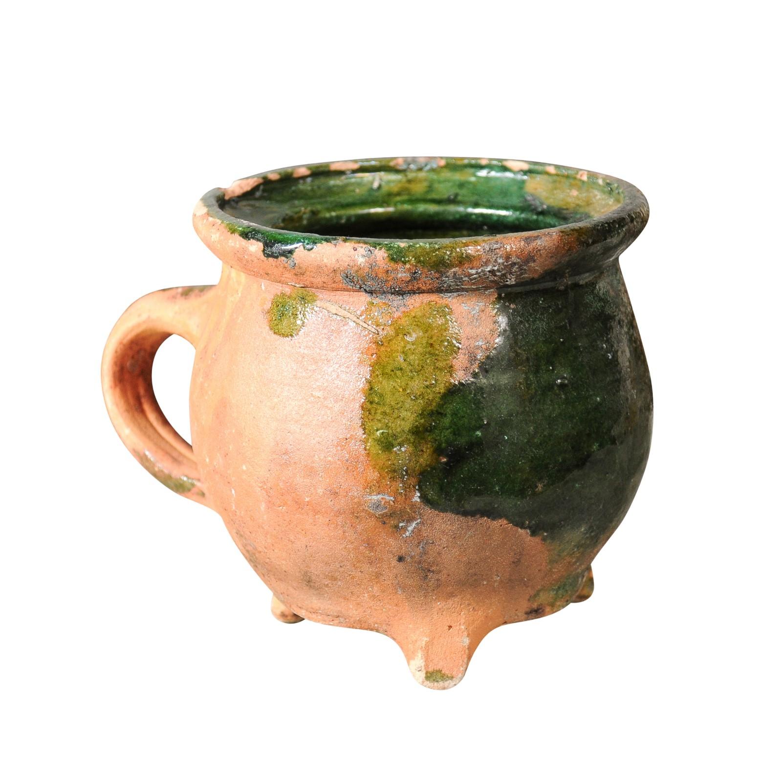 Cerámica francesa provincial del siglo XIX esmaltada en verde con base trípode y asa