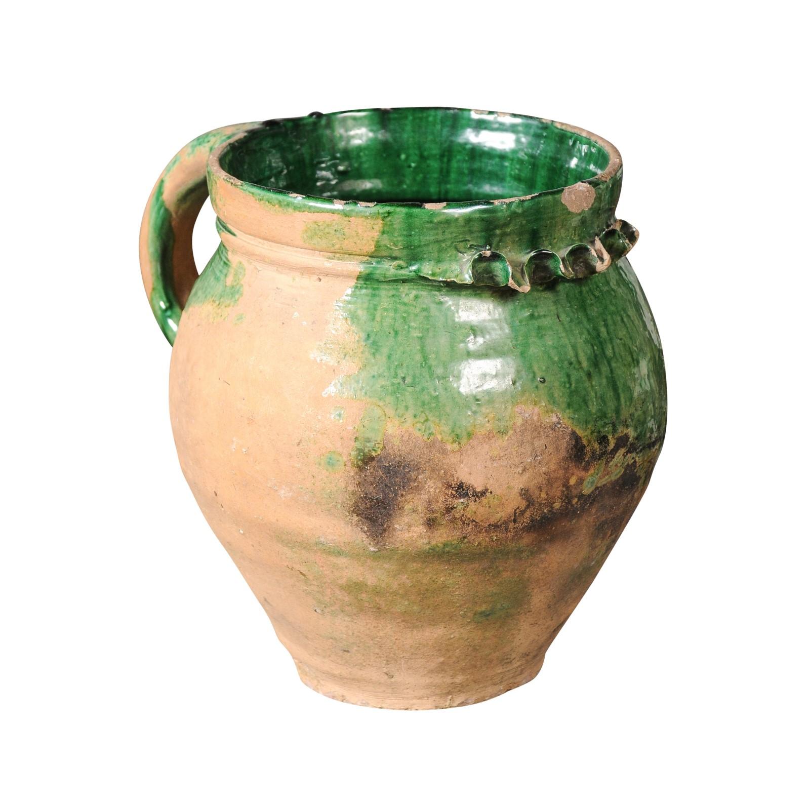 Poterie provinciale française du 19e siècle, à glaçure verte, poignée arrière moulée, goutte à goutte et caractère rustique. Une captivante pièce de poterie provinciale française du 19ème siècle, exsudant un charme rustique avec sa glaçure verte, sa