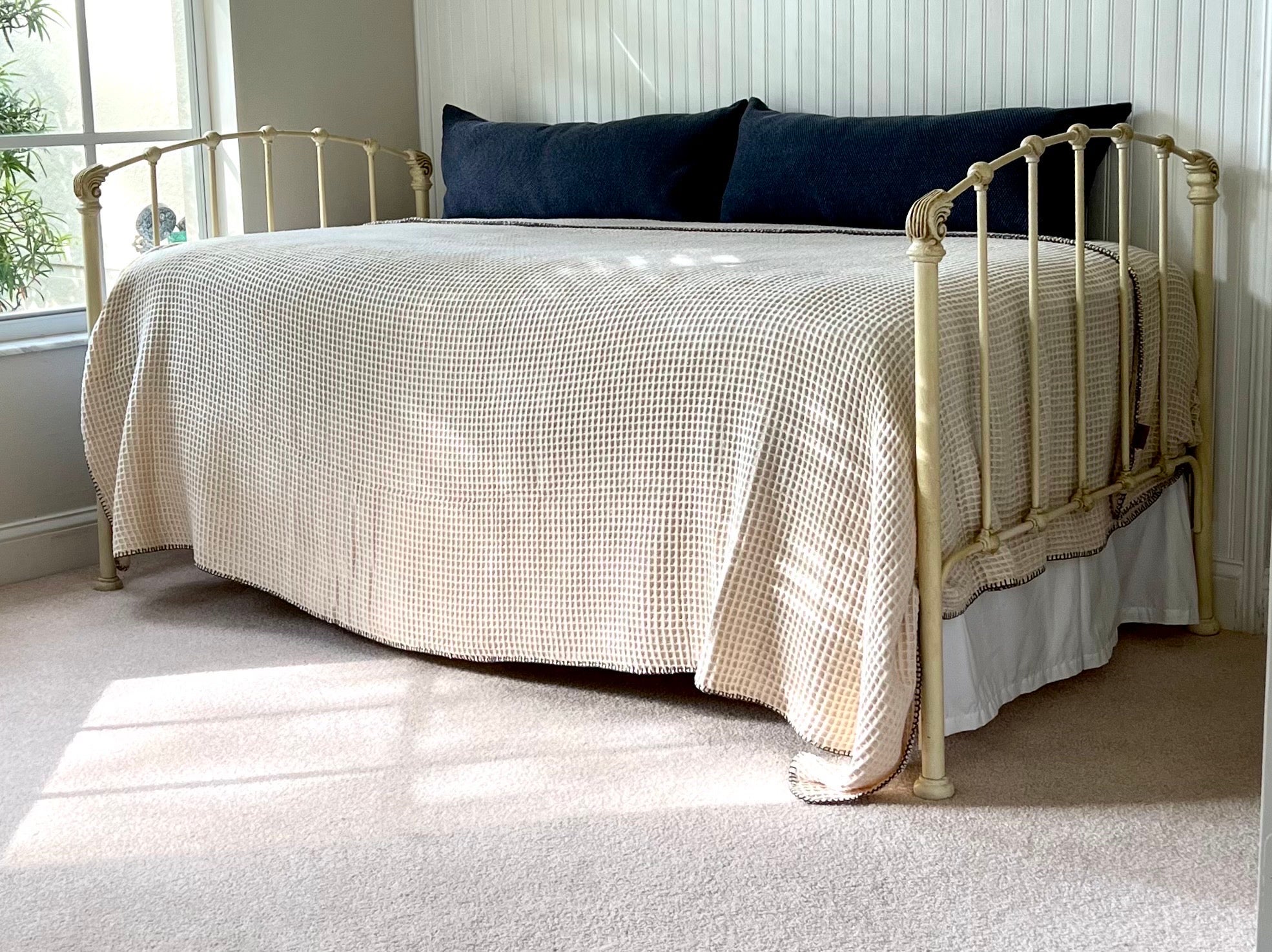 A Classic French Provincial style wrought iron single bed or day bed. The daybed / single bed has sober lines, elegant detailing and is hand painted in a pleasant cream patina. It is very sturdy and fully stable and suitable for sleeping and / or