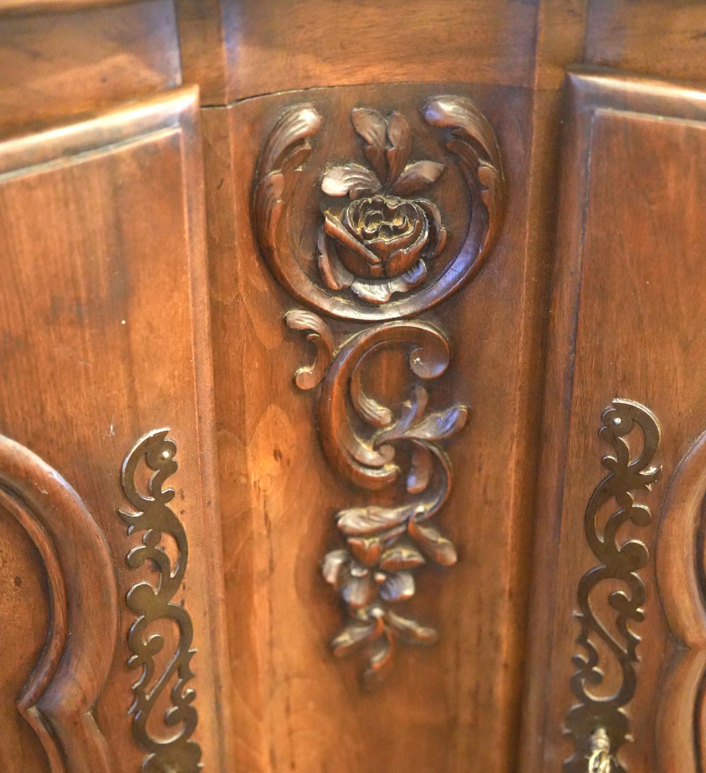 French Provincial 19th Century Walnut beautifully shaped and carved two door. Terminated on carved escargot feet. 