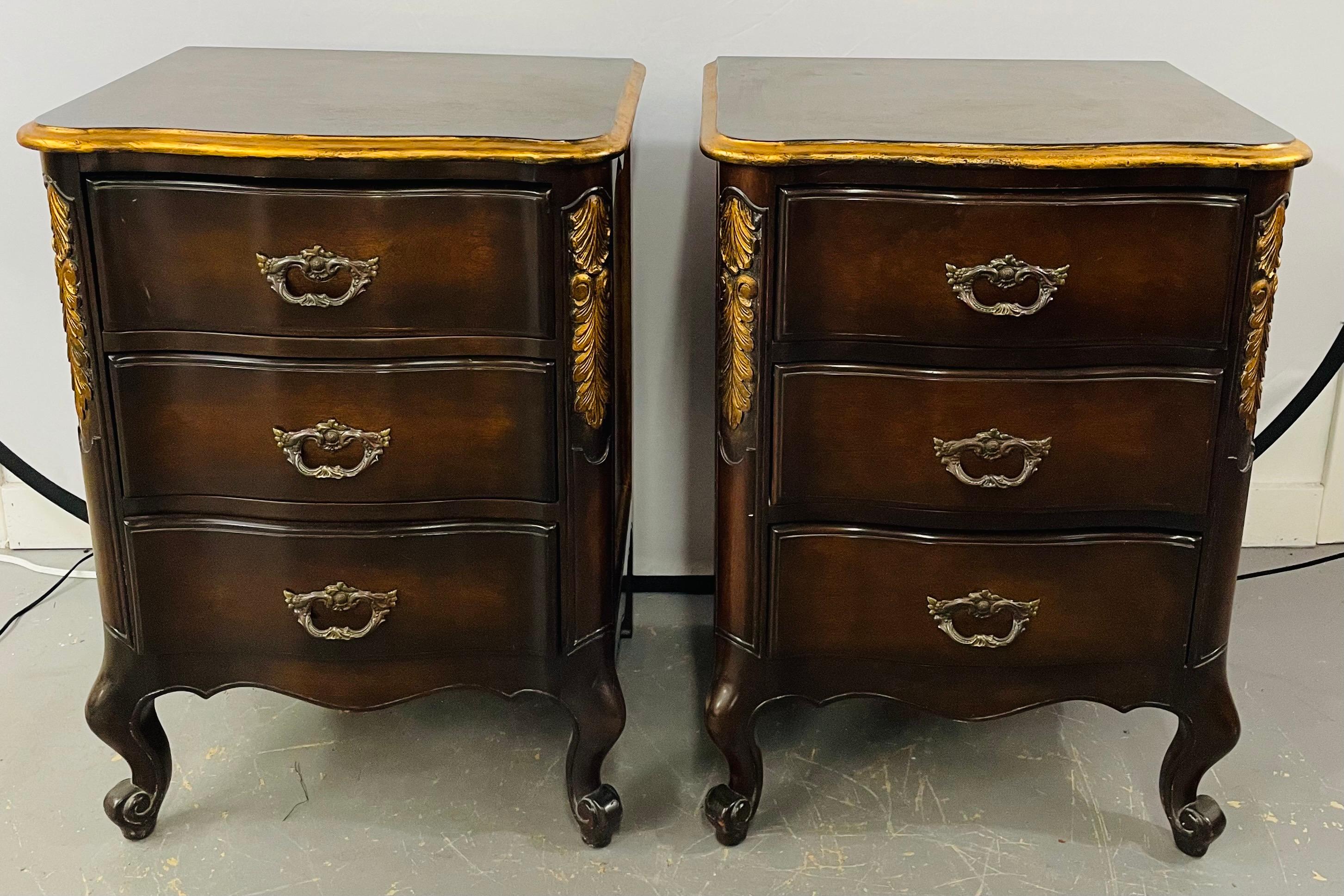 An early 20th century pair of French provincial / Country nightstands finely hand carved in solid Mahogany and showing a beautiful curve and acanthus design gilt decorated. Each nightstand features three drawers and original pulls. The timeless
