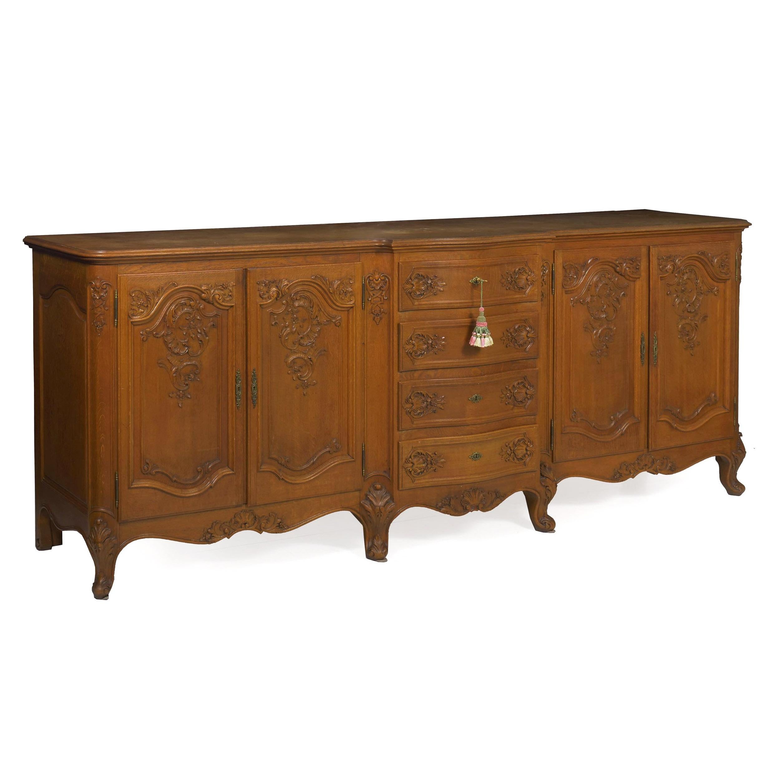 This powerful carved oak buffet is a true statement piece. With a massive length of 101 inches, it is an absolute strikepoint piece. Crafted beautifully out of solid golden oak, the drawers are hand-dovetailed in the typical manner and the facade is