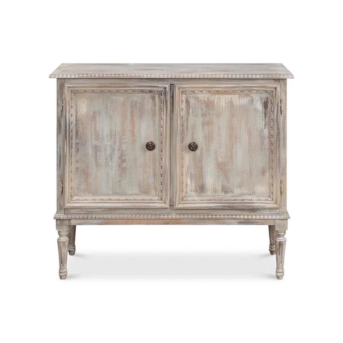 A refined classic inspired by Louis XVI design. The antiqued great wash and painted finish is meticulously distressed to achieve a classic, aged look, while the classic carved elements enhance its charm. Raised on fluted tapered legs, this cabinet