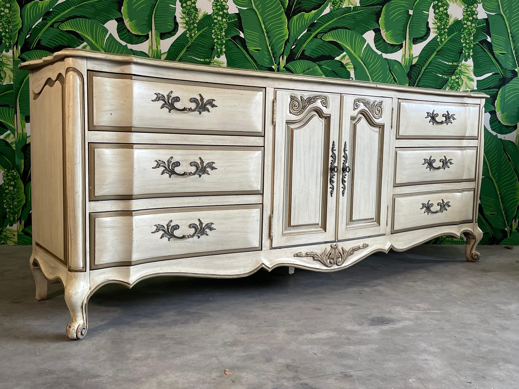 Vintage 20th century French provincial dresser features bombe style detailing, cabriole legs, and scrolled feet. Shaped top and skirt along with bronze hardware. Good condition with minor imperfections consistent with age, see photos for condition