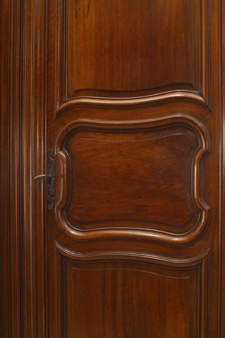 French Provincial (18th Century) two door large scale armoire in walnut with original hardware and shield, bird, and foliate carving on cornice.
 