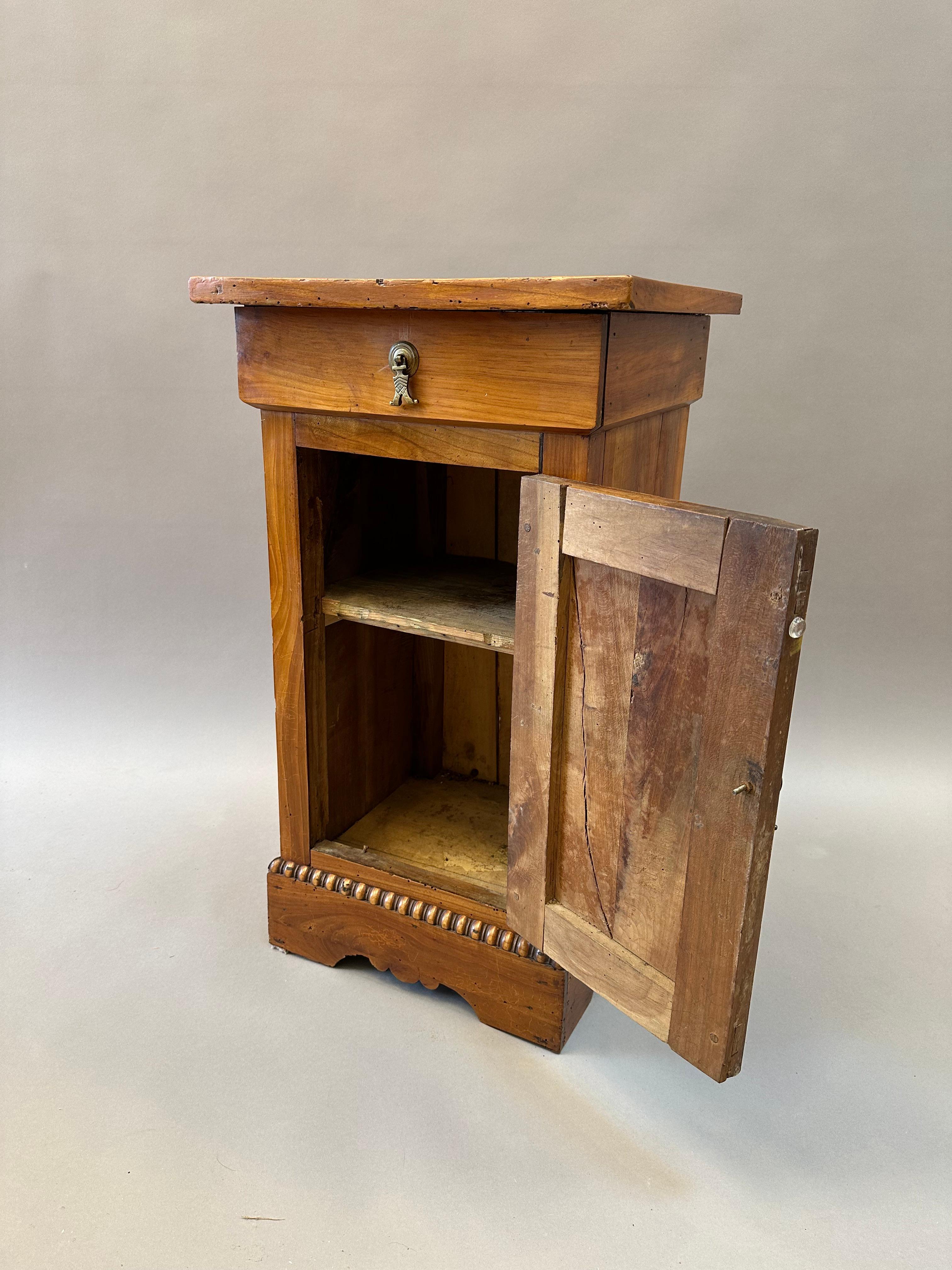 Small French Provincial Charles X Cabinet or Night Stand. Made of Pearwood with and Inlaid Geometric Top over a single Drawer with a “Book-matched” Cupboard Door above Molded and Shaped Bracket Feet. Made in Normandy circa 1820.