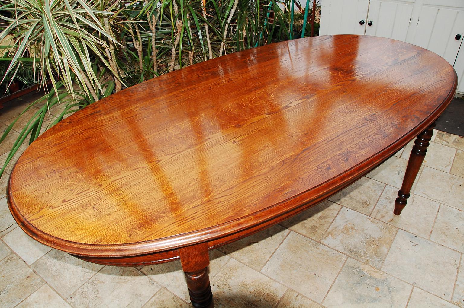 French Provincial oak oval dining table with turned legs and molded top. This elegantly shaped country table has been refinished with classic french polish techniques and is ready to be used and enjoyed. The top was removed and attached using a