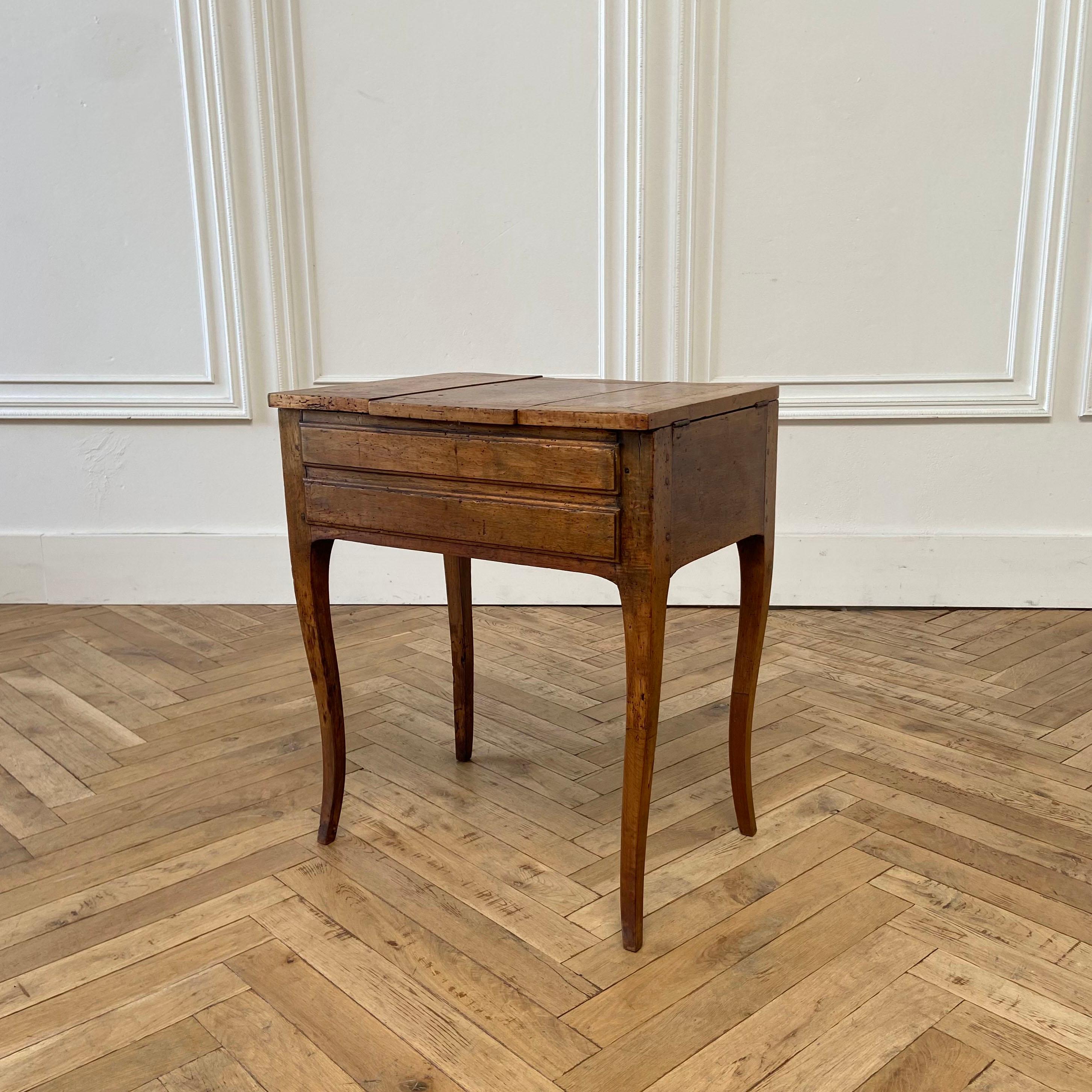 A French provincial fruit wood poudreuse,
first half 19th century
The shaped rectangular top with central hinged mirror flanked by a pair of hinged compartments over a faux drawer, a slide and two small drawers on slender cabriole