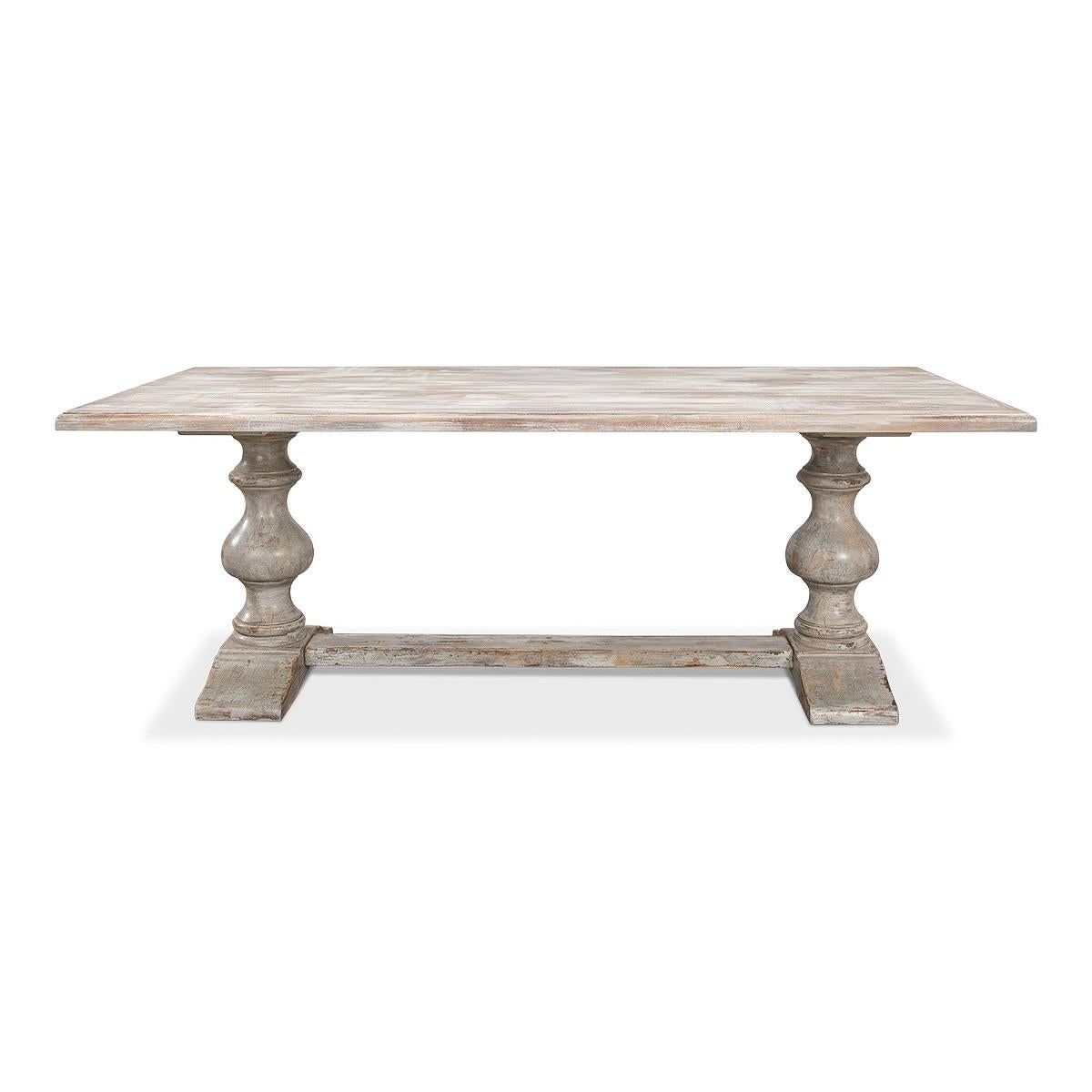 A French Provincial greyed wash painted refectory table with a unique distressed greyed painted finish. With a molded edge and raised on baluster turned legs in a trestle form with a stretcher. 

Dimensions: 84