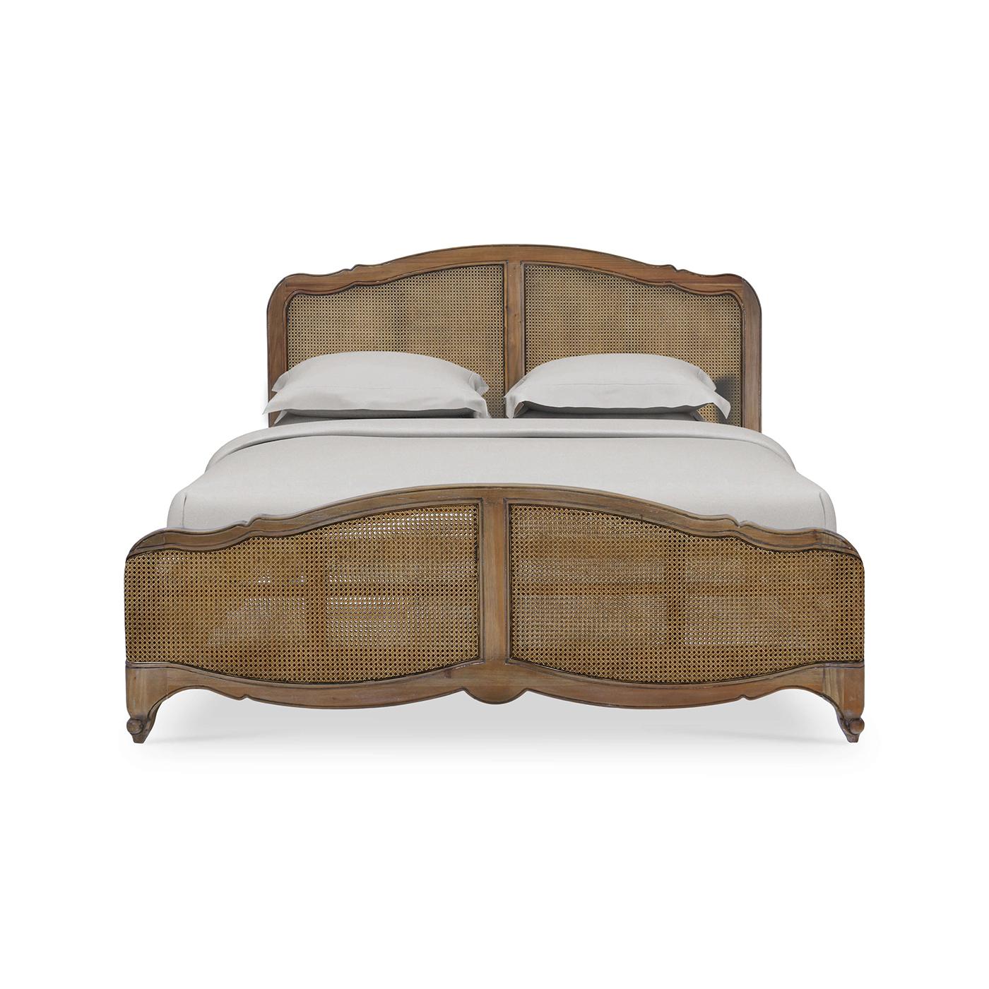 An 18th-century inspired, Louis XV-style carved bedframe, in a medium hand-rubbed and distressed Straw Wash finish.

The serpentine crest headboard features inset caned rattan in a glaze finish. The serpentine footboard with inset rattan and curved