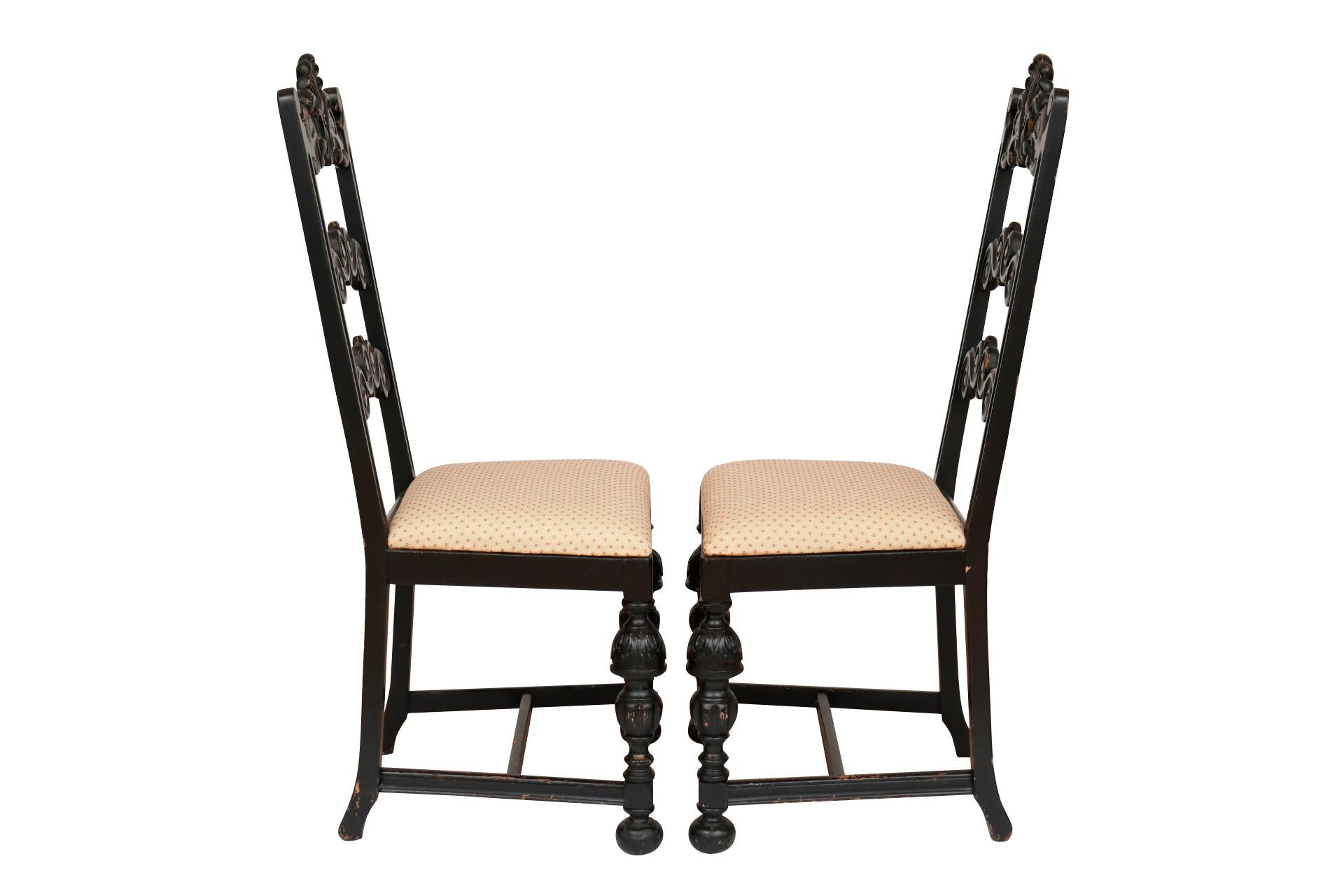 A pair of William & Mary ladderback side chairs. Tall chair backs are constructed with three cross rails elaborately carved with serpentine scrolls and a central plume of feathers. Square seats are upholstered in a yellow fabric stitched with a
