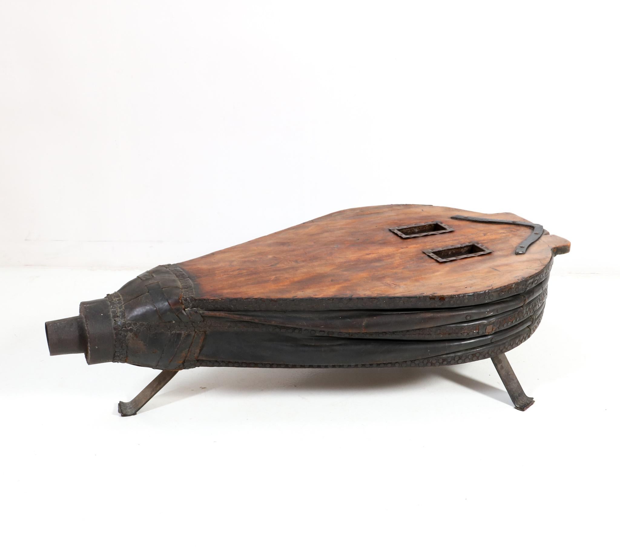 Magnificent and large French Provincial blacksmith forge bellows coffee table.
Striking French design from the 1860s.
Fruitwood and leather top on a custom made wrought iron stand.
This wonderful and highly decorative French Provincial blacksmith