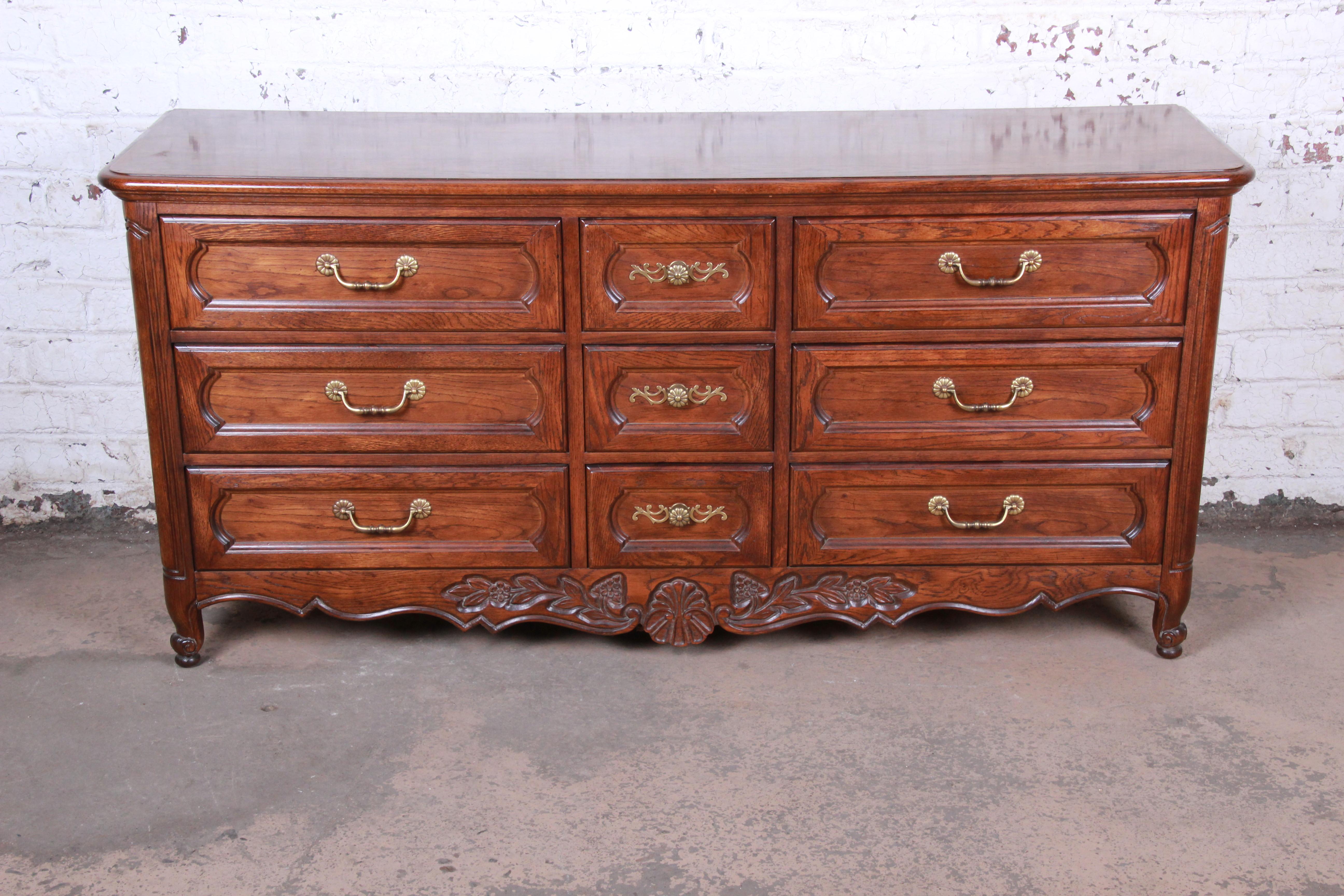 A gorgeous French Country Louis XV style triple dresser or credenza

By Hickory Manufacturing Co.

USA, 1970s

Oak and brass

Measures: 68.75
