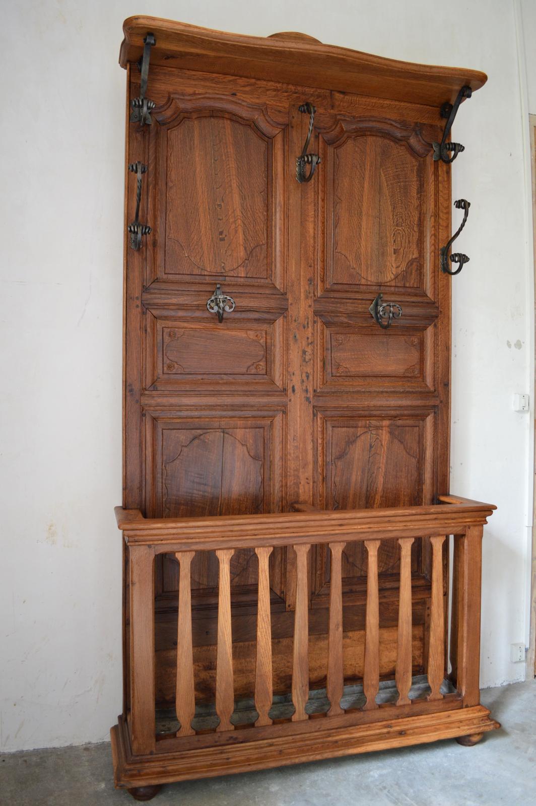 Superb coat rack in carved chestnut and wrought iron hooks.

It is a beautiful and very original coat rack: the bottom is made of two old cabinet doors from the late 18th-early 19th century. These doors have been used by a talented cabinetmaker to