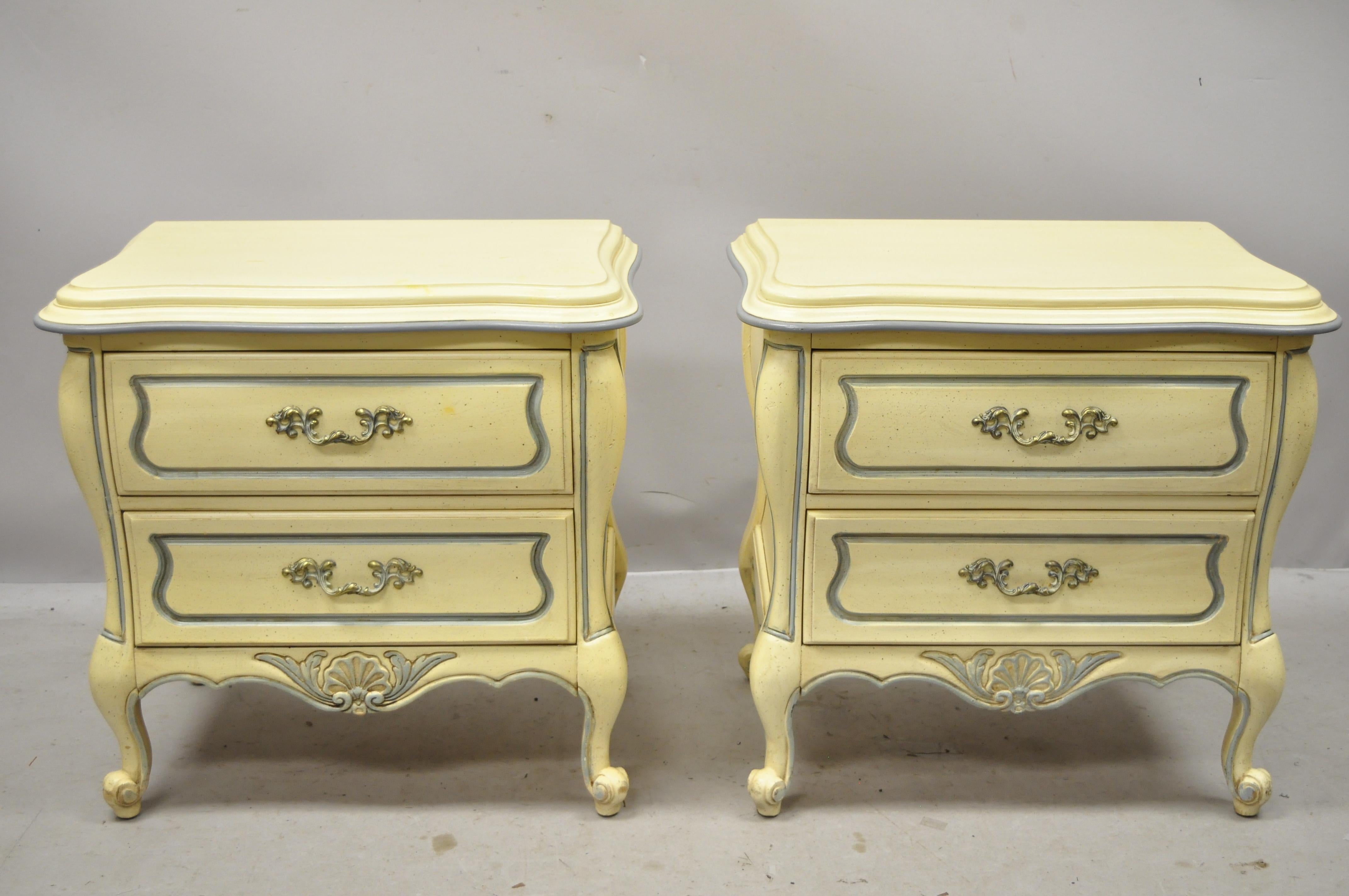 French Provincial Louis XV country style cream lacquer bombe nightstands tables, a pair. Item features cream painted finish with blue trim, shell carved accents, 2 dovetailed drawers, cabriole legs, solid brass hardware, very nice vintage item,
