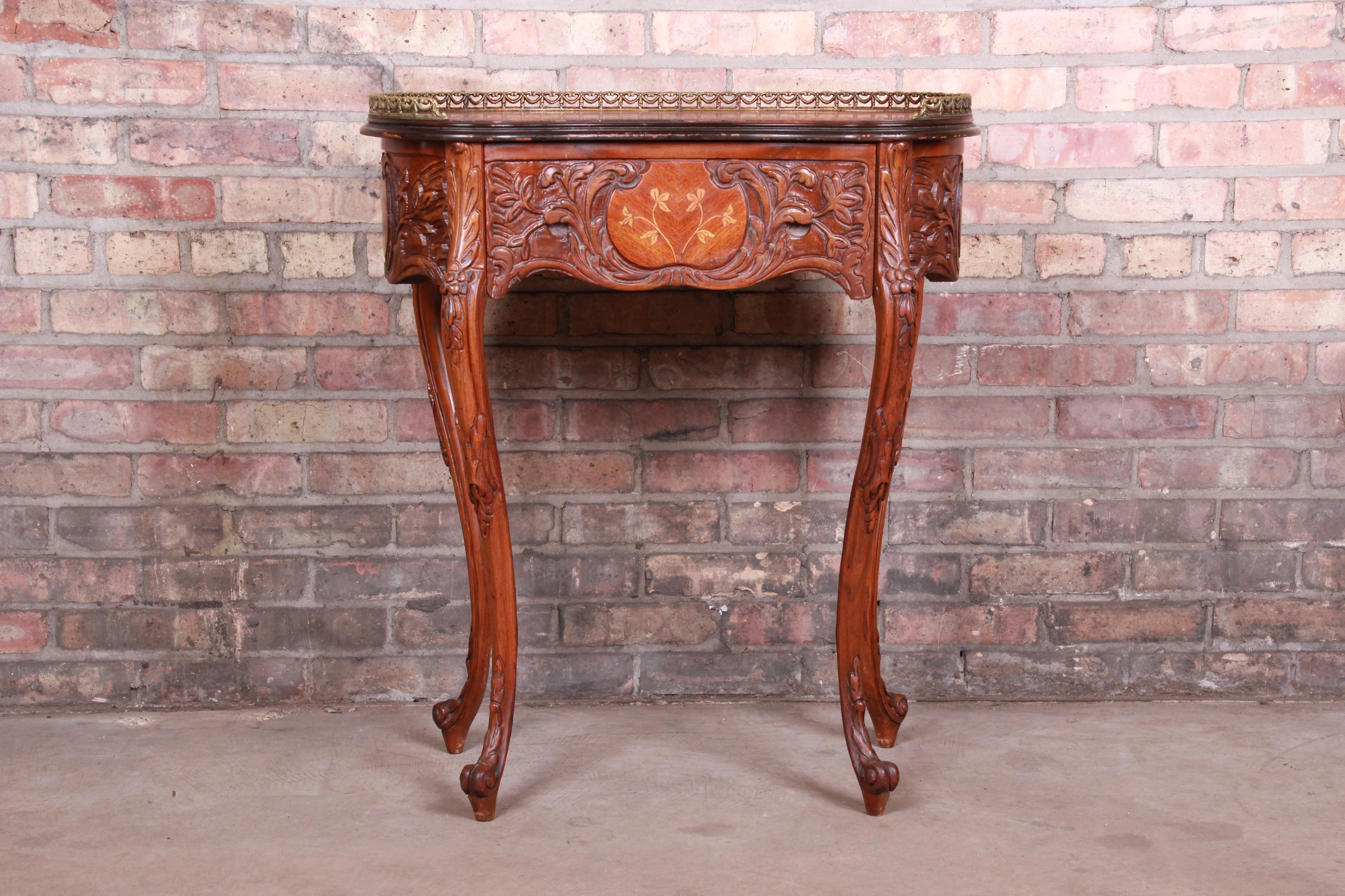 A gorgeous French carved Louis XV style kidney-shaped nightstand or side table

circa 1940s

Carved mahogany, with inlaid satinwood floral marquetry and brass gallery.

Measures: 27.5