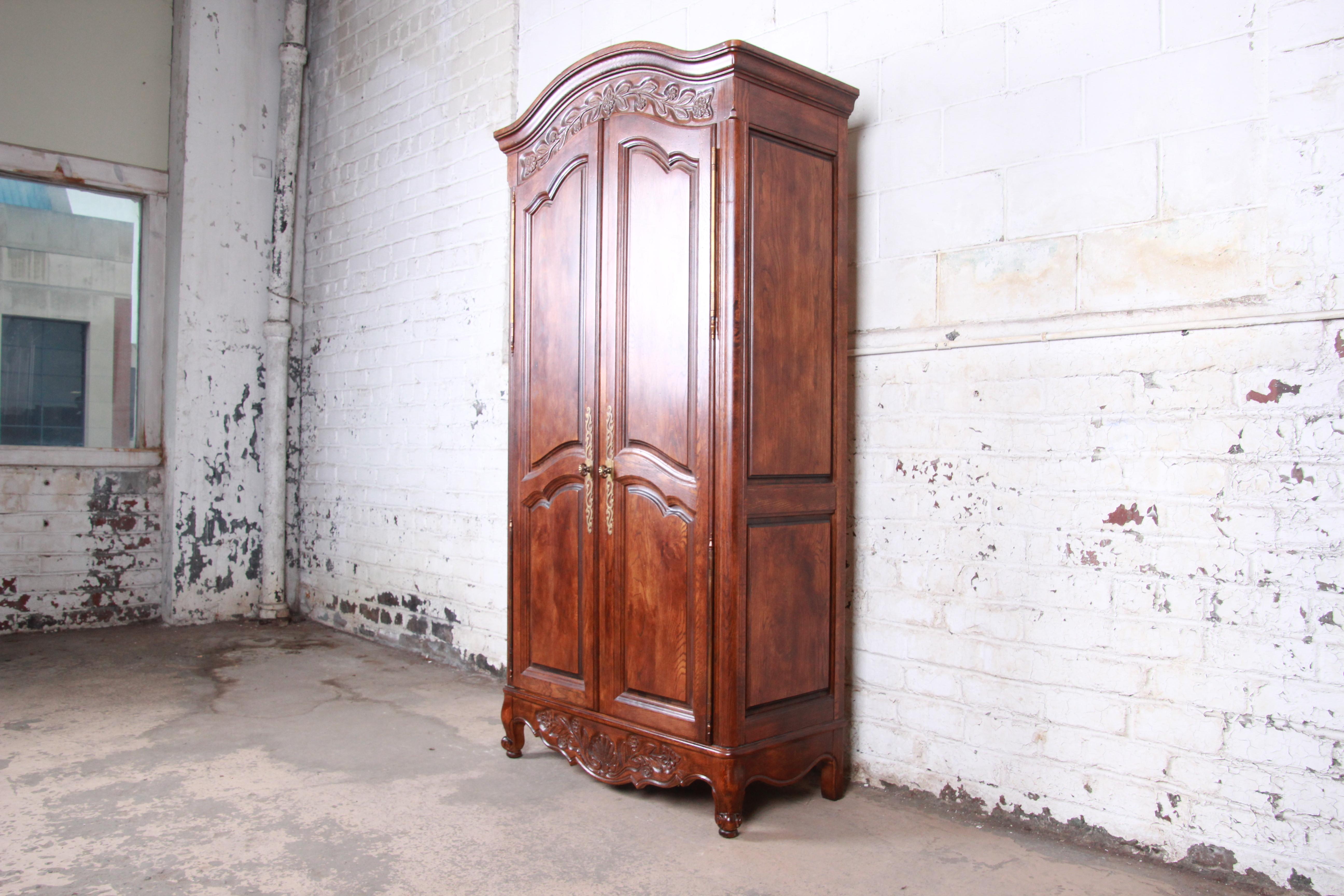 A gorgeous French Country Louis XV style oak wardrobe or armoire dresser

By Hickory Manufacturing Co.

USA, 1970s

Oak and brass

Measures: 38.38