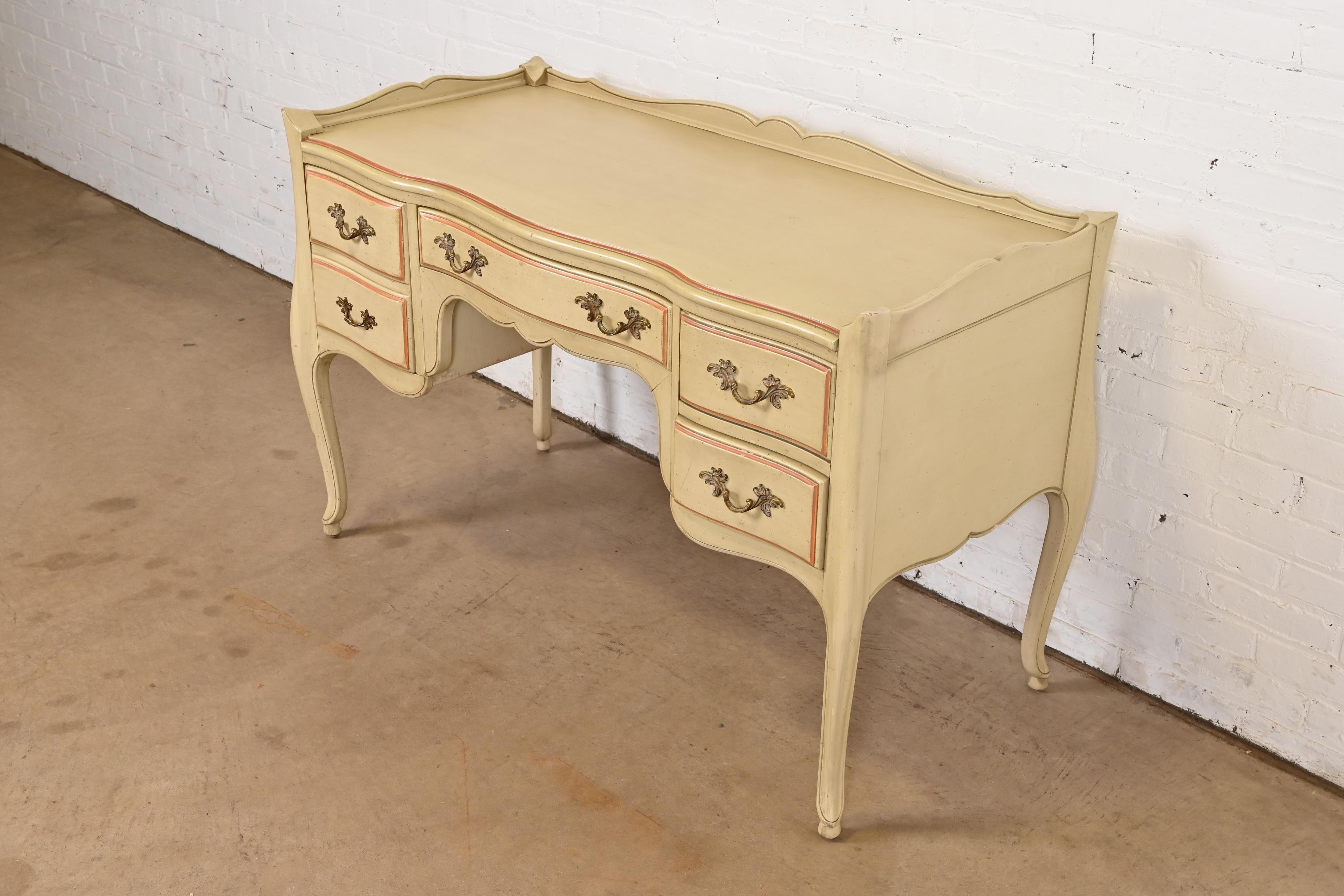 A beautiful French Provincial Louis XV style writing desk

Attributed to John Widdicomb

USA, Circa 1960s

Solid cherry wood, with original cream and pink painted finish, and original brass hardware.

Measures: 50