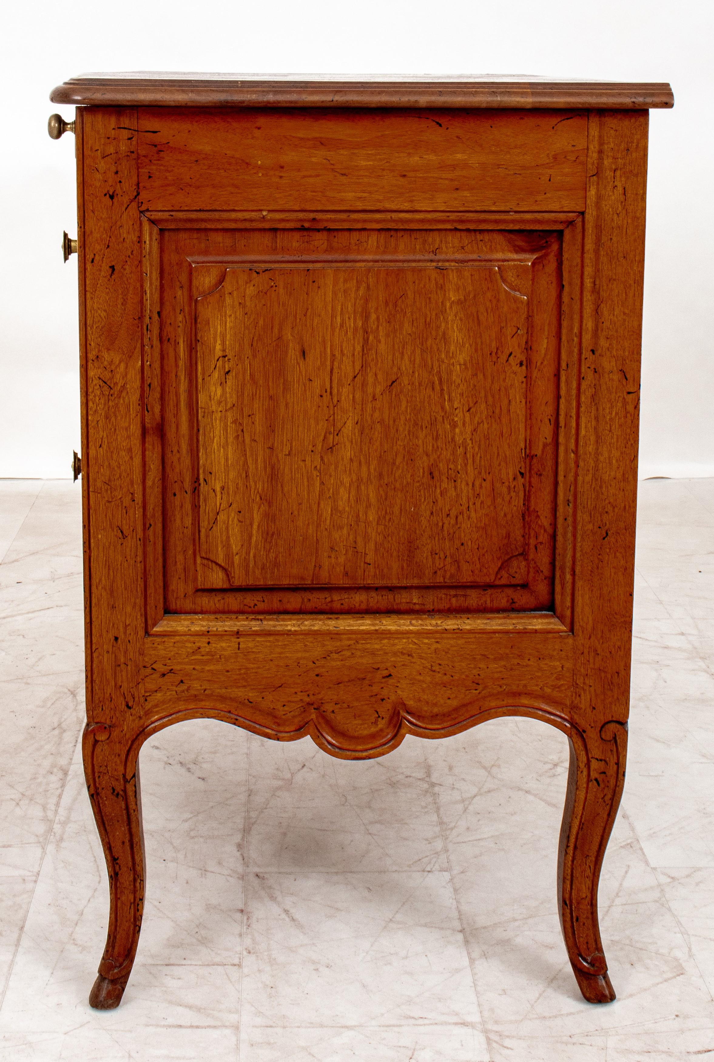  French Provincial Louis XV Style Walnut small commode. Here are the details:

Style: French Provincial Louis XV
Material: Walnut
Features:
Shaped rectangular top
Slide
Two short conforming paneled serpentine drawers
Scrolling cabriole feet
Drawer
