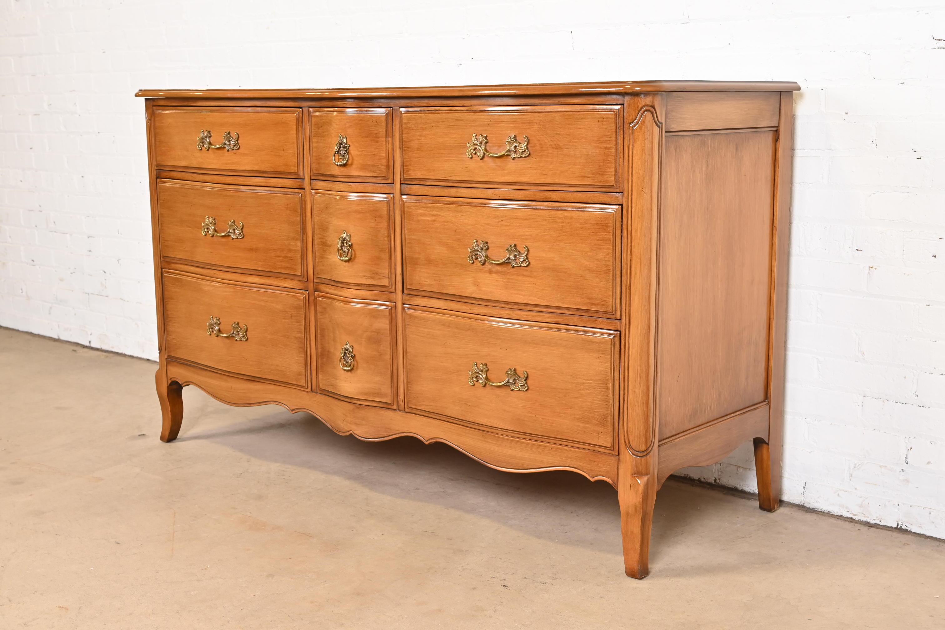 A gorgeous French Provincial Louis XV style nine-drawer dresser or credenza

By Davis Cabinet Co.

USA, 1950s

Carved solid beech wood in provincial walnut finish, with original brass hardware.

Measures: 60