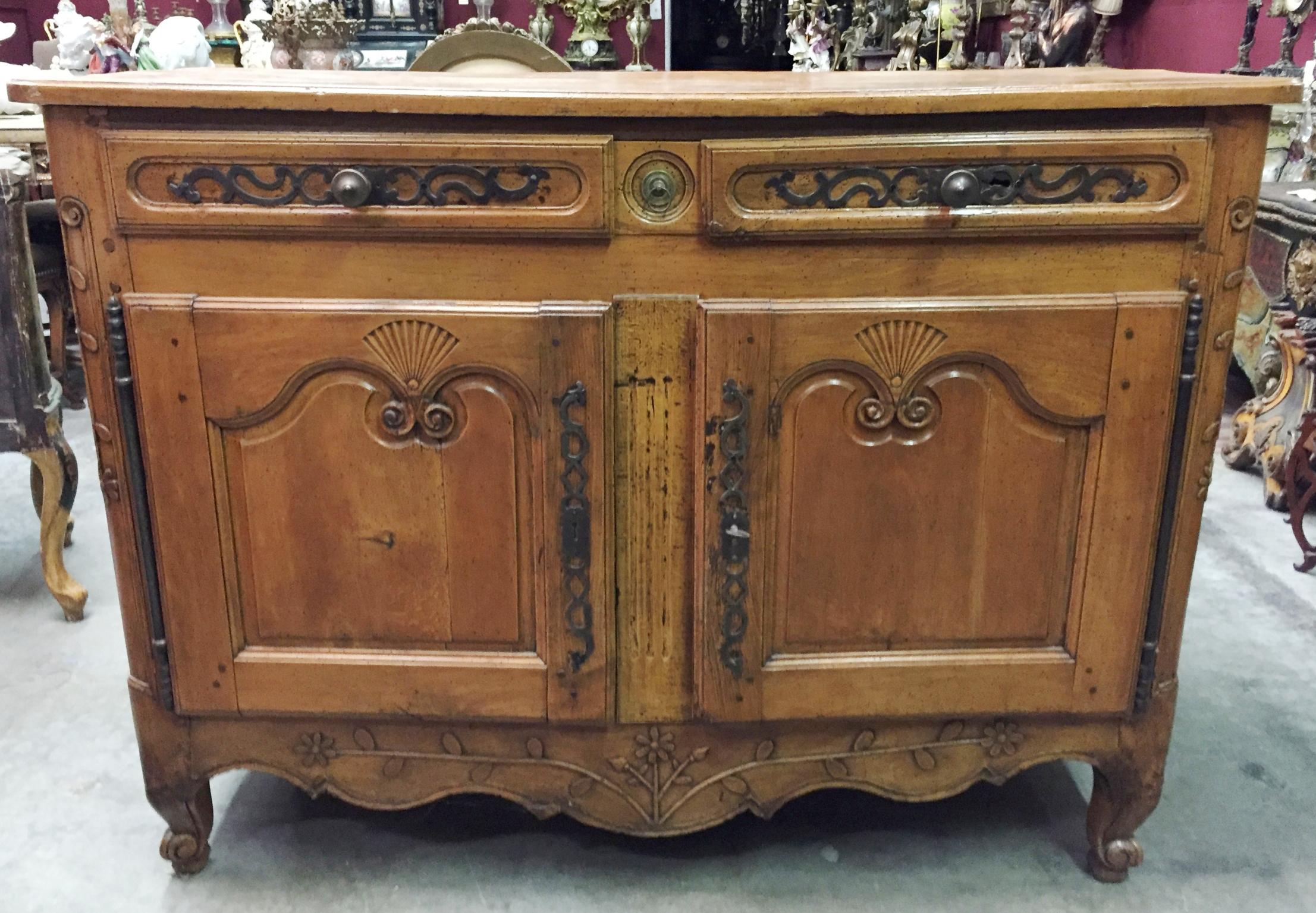 Beautiful 18th century French Provincial Louis XV carved walnut buffet. The moulded rectangular top over two mounted drawers and two hinged carved doors above a carved skirt with sunflower and foliage motif, supported by four cabriole legs.
The