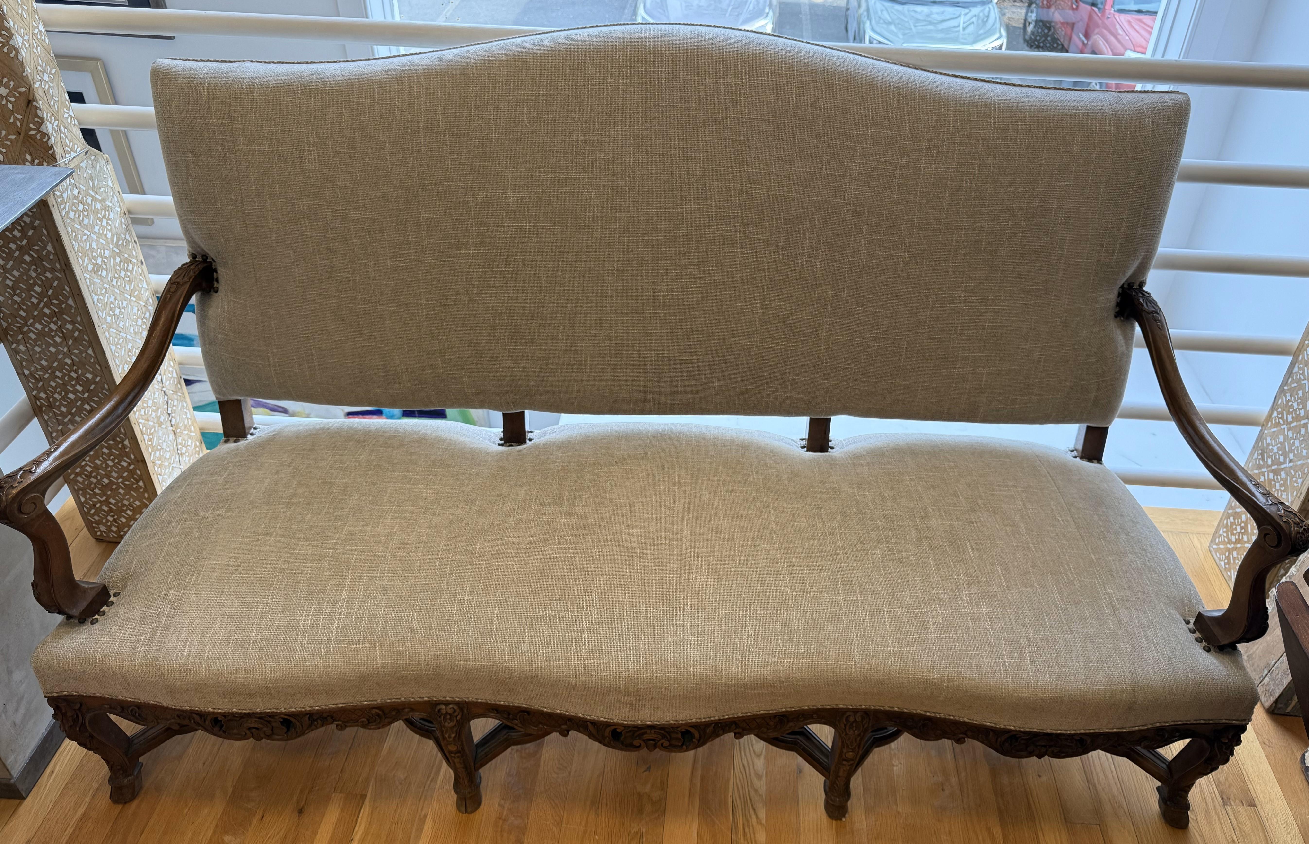 French Provincial Louis XV Walnut Settee. Made of Circassian Walnut with scrolled arms over eight carved and molded legs with cross stretchers. Recently reupholstered, great proportions, and very comfortable. Made in Provence circa 1820.

A graceful