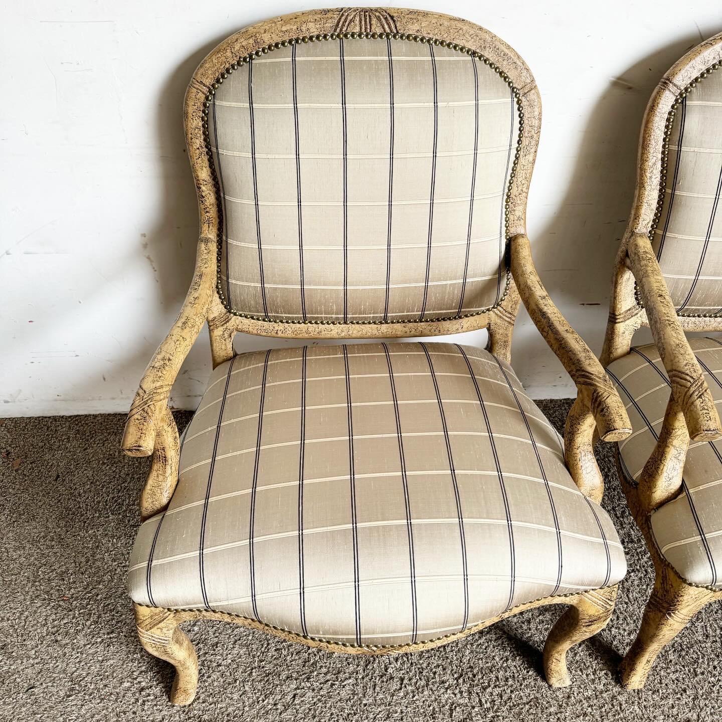 Embrace the elegance of French Provincial design with this pair of Lounge Chairs, distinguished by brass nails. Upholstered in luxurious fabric, these chairs marry classic lines with sophisticated accents, offering timeless appeal for both