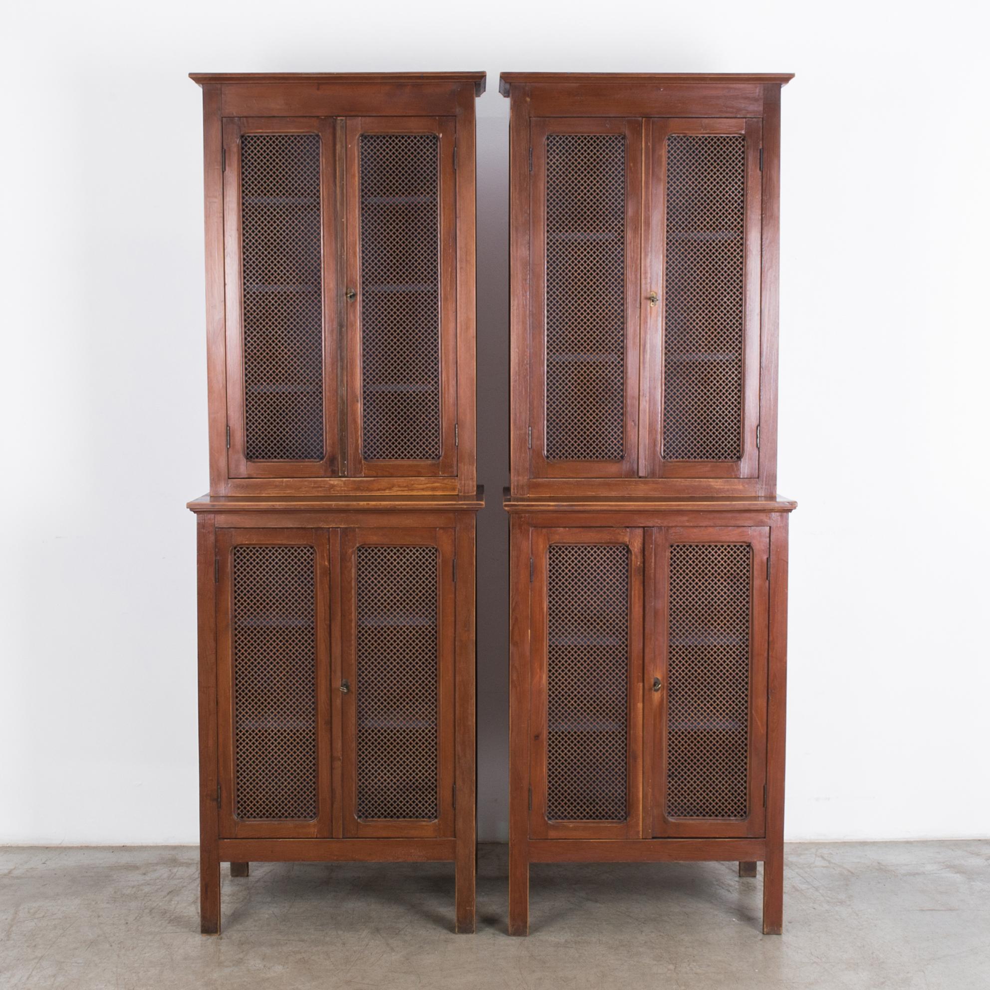 A pair of pantry cabinets from France, circa 1920. A distinctive regional style features perforated metal mesh door panels, originally designed to keep food fresh at the proper heat and humidity. Original finish gives a beautiful warm translucency,