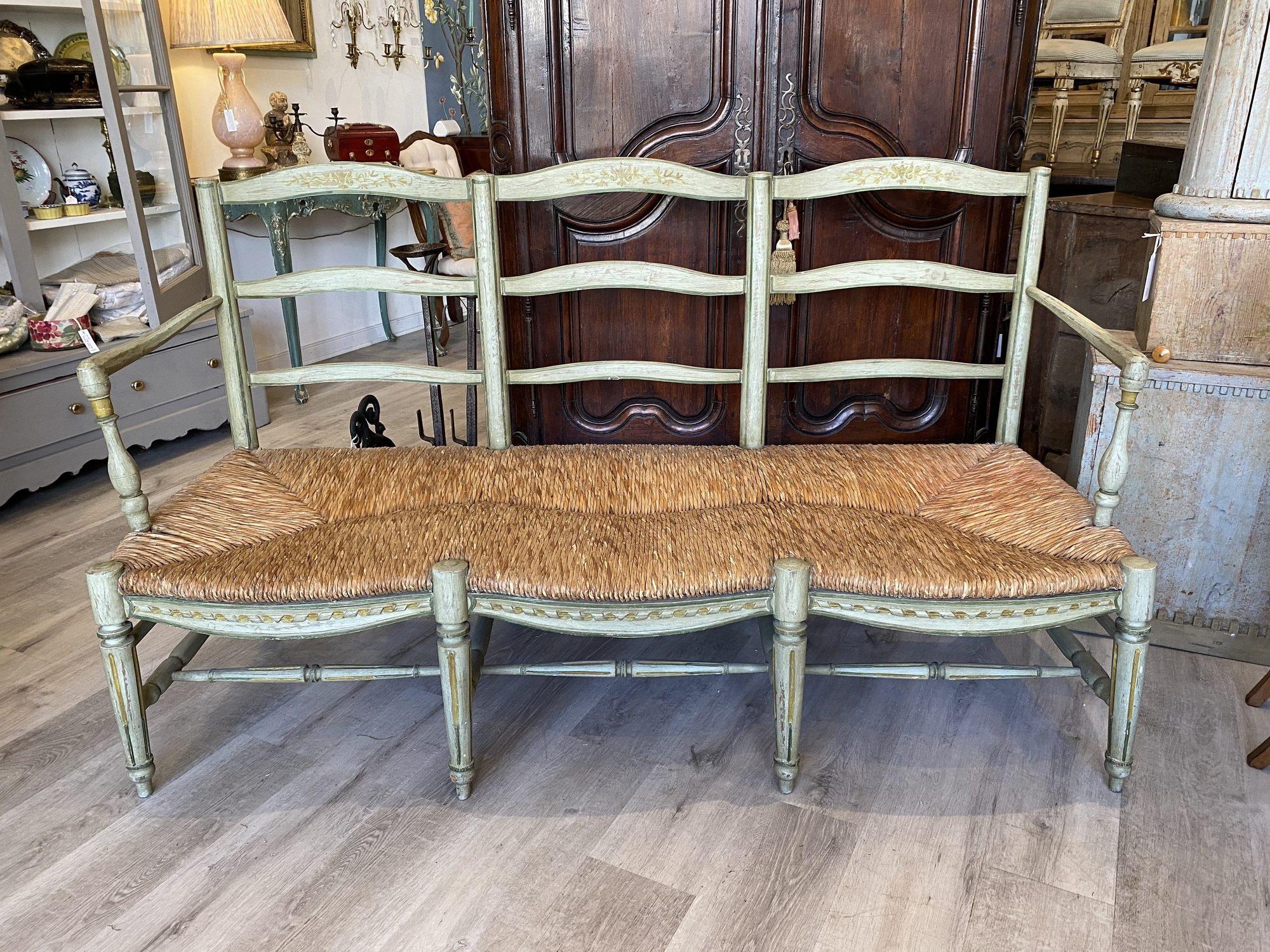 Beautiful French provincial rush seat settee bench with a matching pair of fauteuils (armchairs), pair of armchairs, beechwood, hand carved and painted, circa 1780.

The three-seat ladder back settee having green paint and painted floral design on