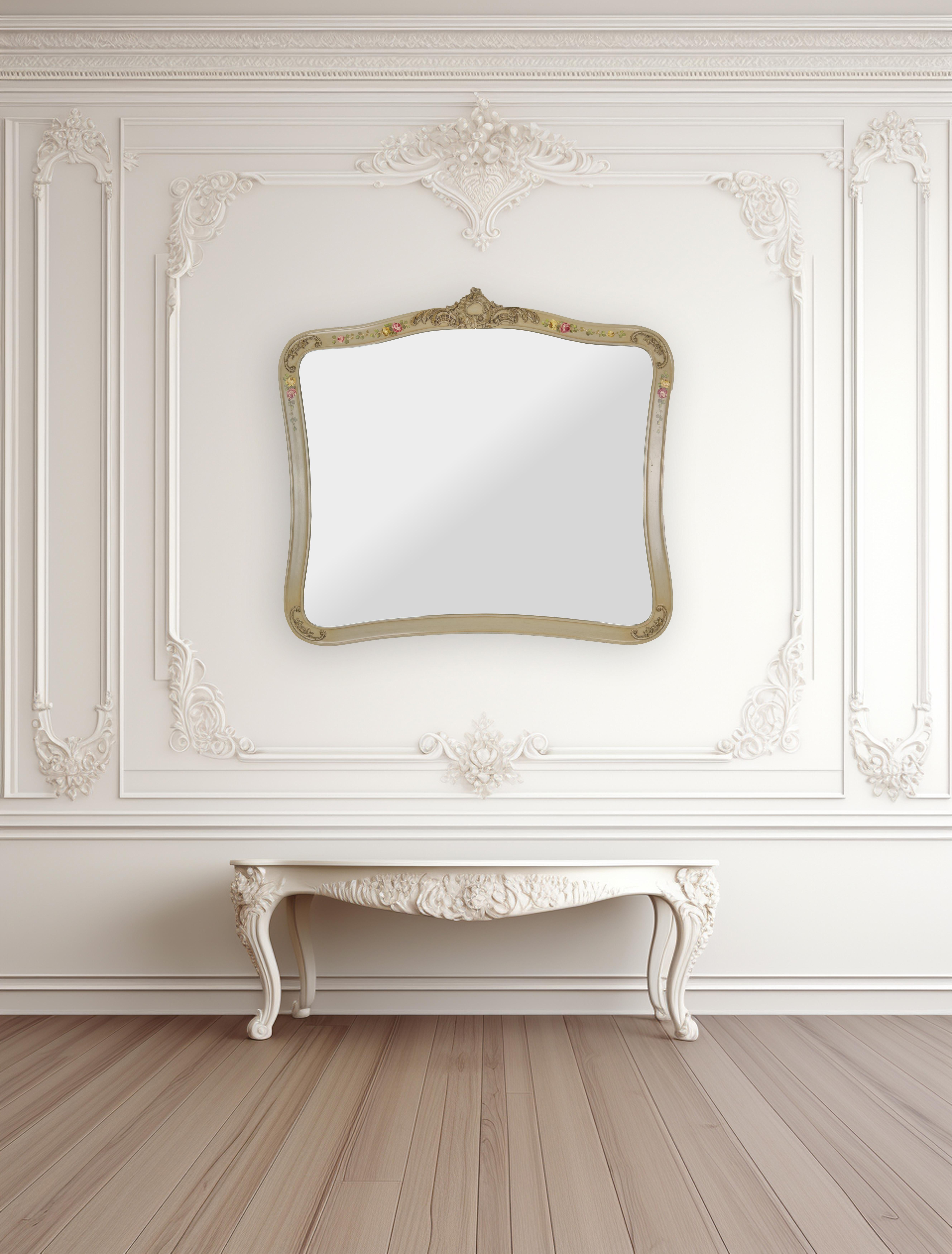 Miroir de style provincial français aux courbes élégantes. Le cadre rectangulaire est fini dans un ton beige doux, créant une toile de fond raffinée et discrète pour les motifs floraux complexes peints à la main qui ornent ses bords. De gracieuses