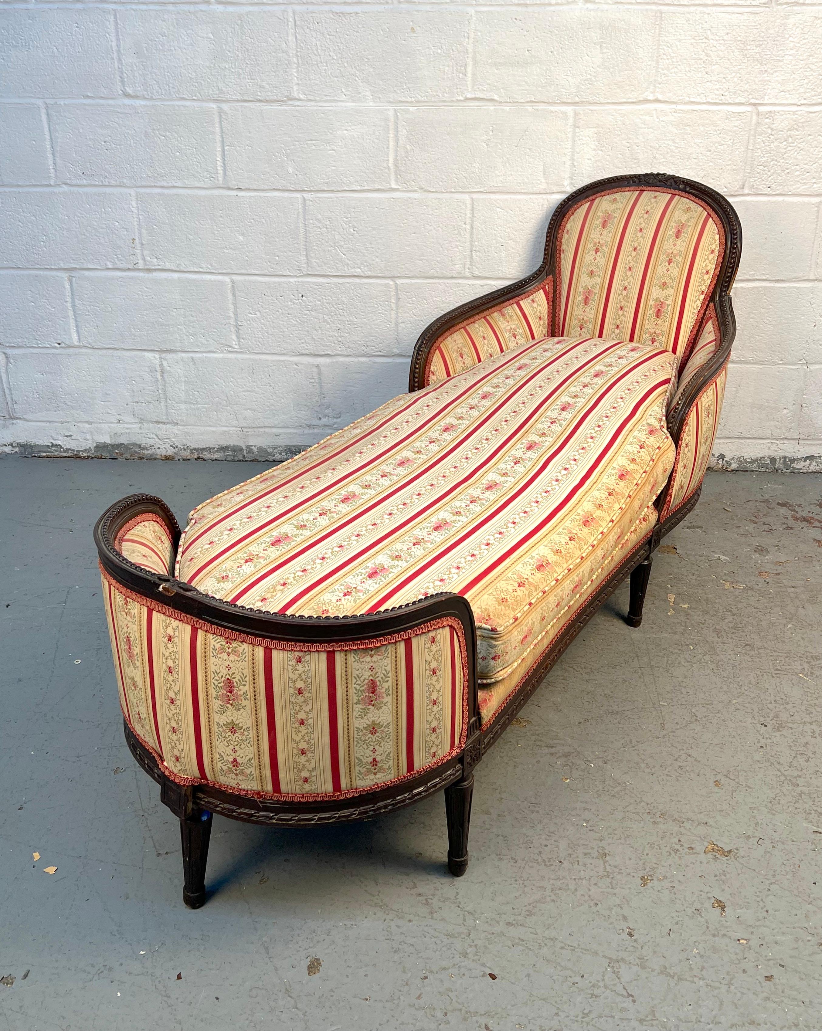 This elegant French provincial chaise lounge settee, crafted in the Louis XV style, features graceful curves, carved details, and a refined silhouette. Its timeless design and comfortable form make it a perfect statement piece for a living room,