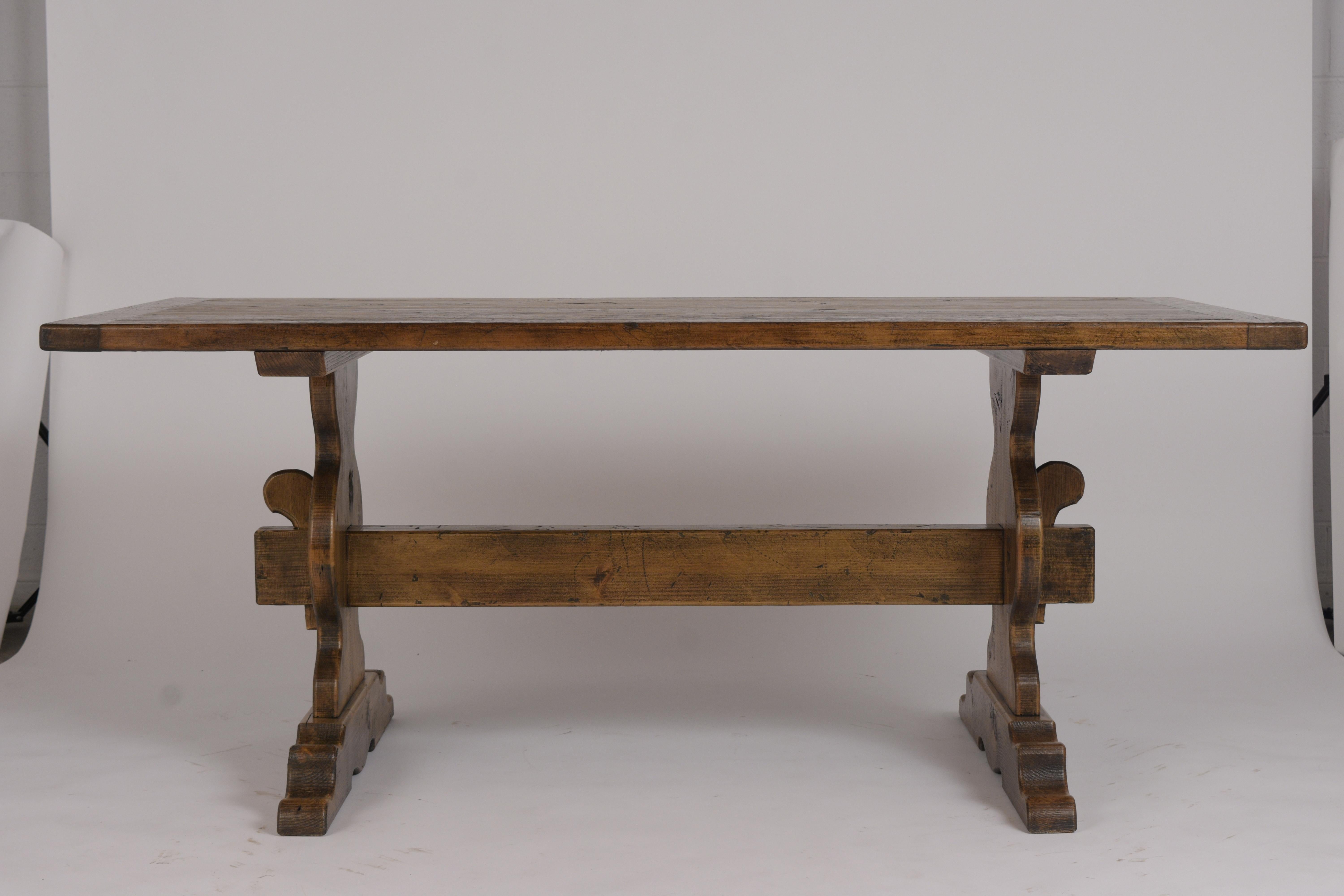 This 1950s French Provincial style dining table is made out of solid pine wood and is in great condition. It has been newly stained in walnut color, waxed and polished developing a beautiful patina finish. This dining table featured a rectangular