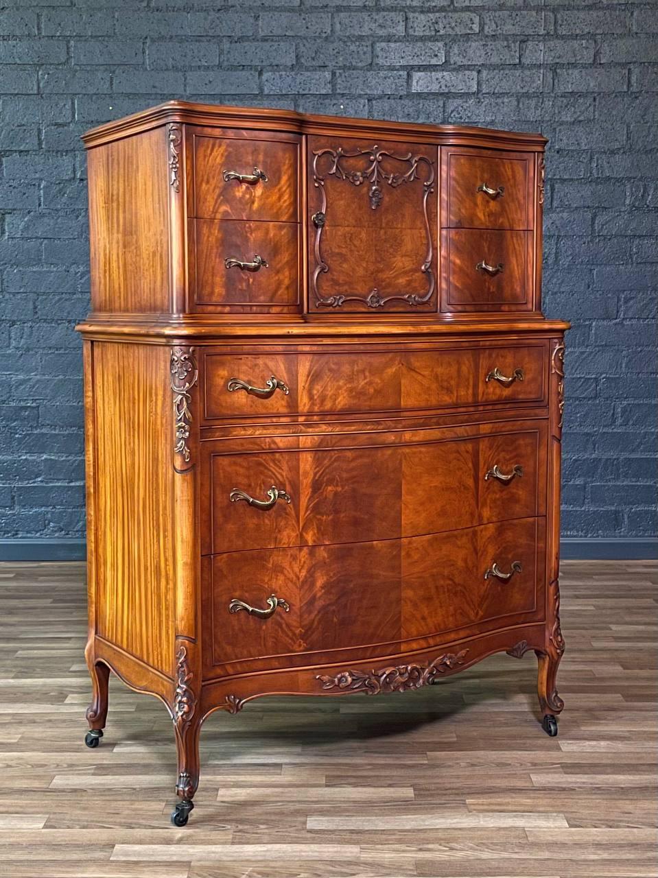 Condition: Original Vintage Condition
Materials: Flame Mahogany, Patinated Brass Handles

This French Provincial style highboy dresser showcases exquisite flame mahogany veneers and elegant serpentine drawer fronts, accented by original patinated