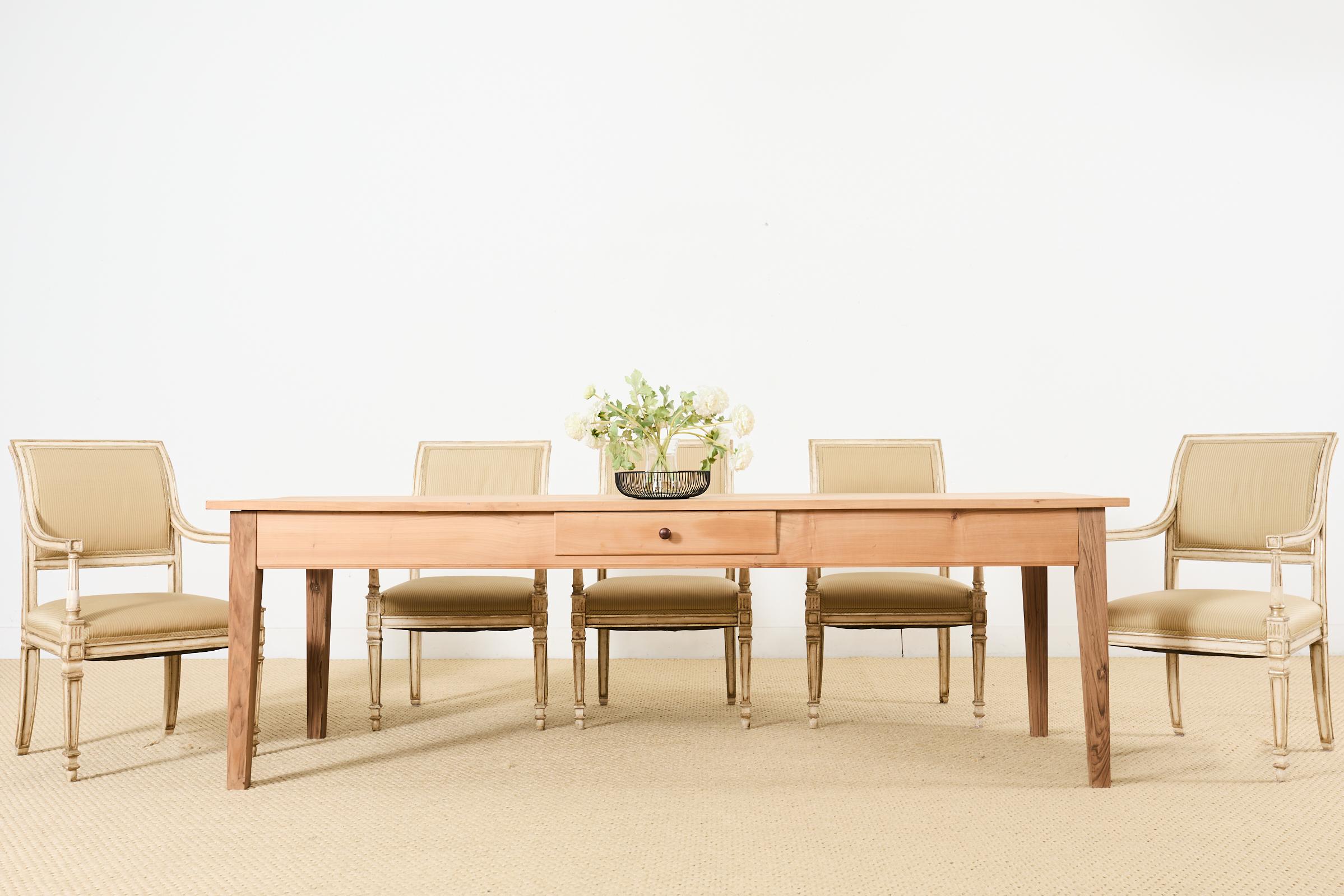 Gran mesa de comedor de granja de madera de frutal o mesa de cosecha de estilo provincial francés. La mesa grande presenta tablones de 2,5 cm de grosor en la parte superior con un acabado natural en bruto que resalta las vetas de la madera y su