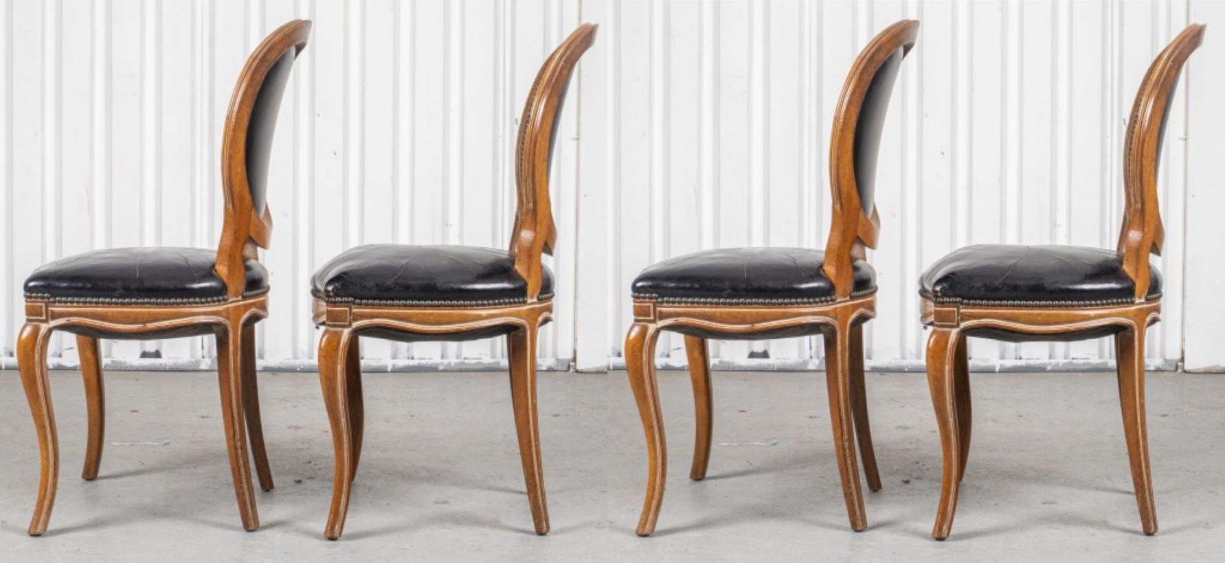 Set of four French Provincial style fruitwood side chairs, upholstered with black leather. 36.5” H x 19” W x 20” D x Seat 19