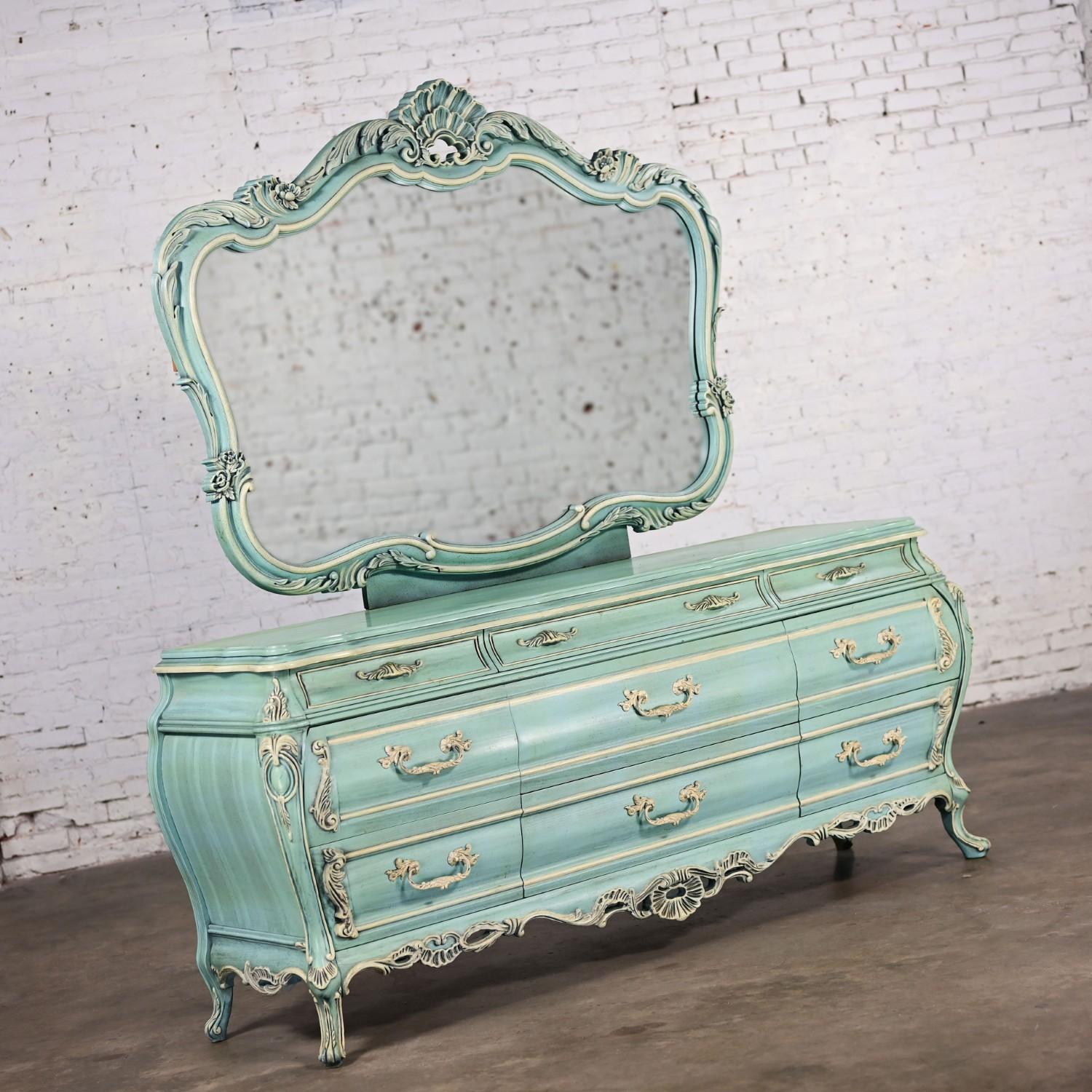 Magnificent vintage French Provincial Renaissance style heavy carved Bombay dresser & mirror with 9 drawers & an antiqued powder blue ceruse factory finish with off-white painted hardware & heavily carved details. Beautiful condition, keeping in