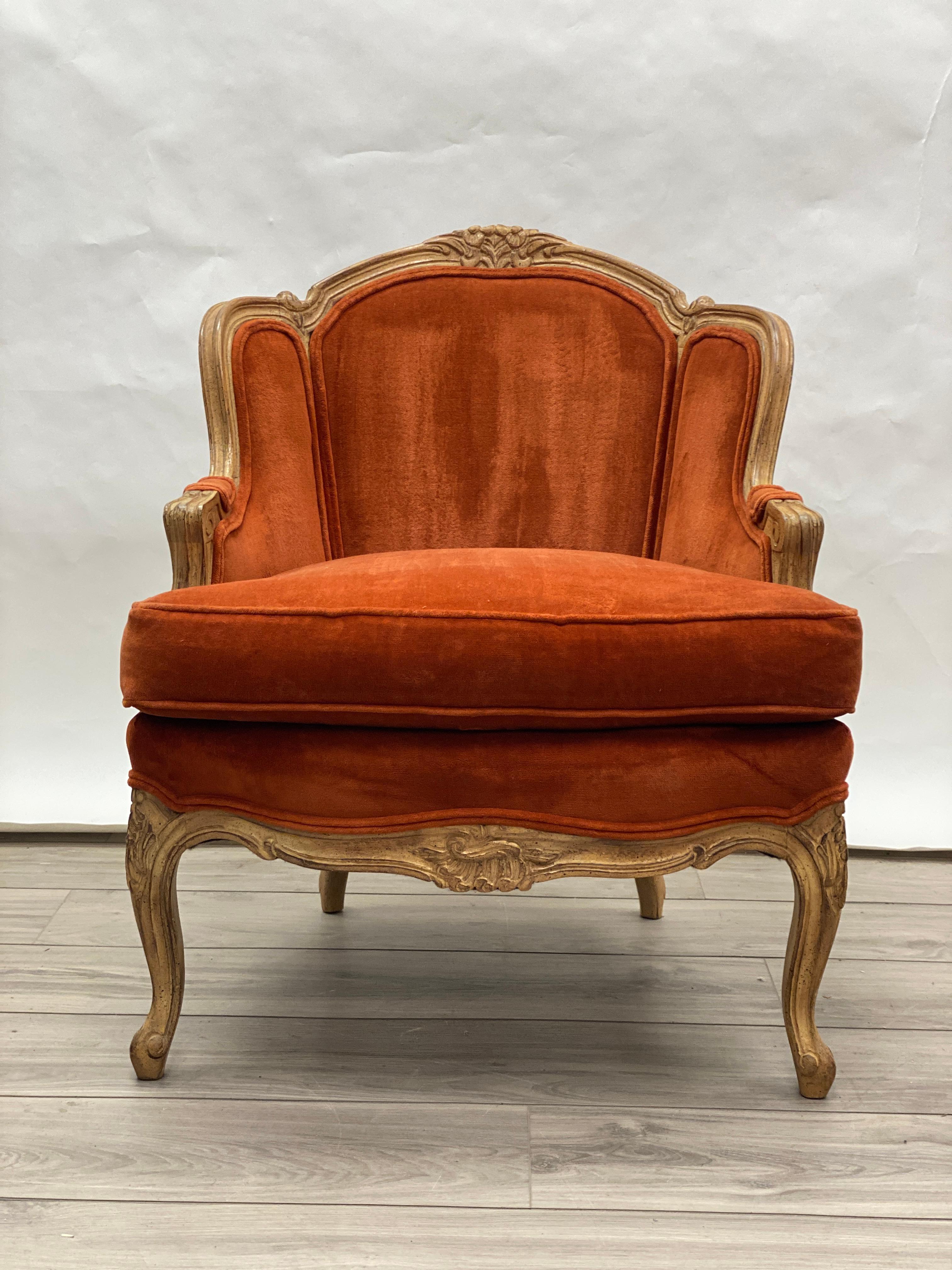 This is a late 20th Centurery Jeffco Manufacturing Louis XV French Provincial style bergere chair. The hand-carved frame is made of oak. It has a distressed glazed oak wood finish. The arms are and back rail are reeded. There is a central foliate