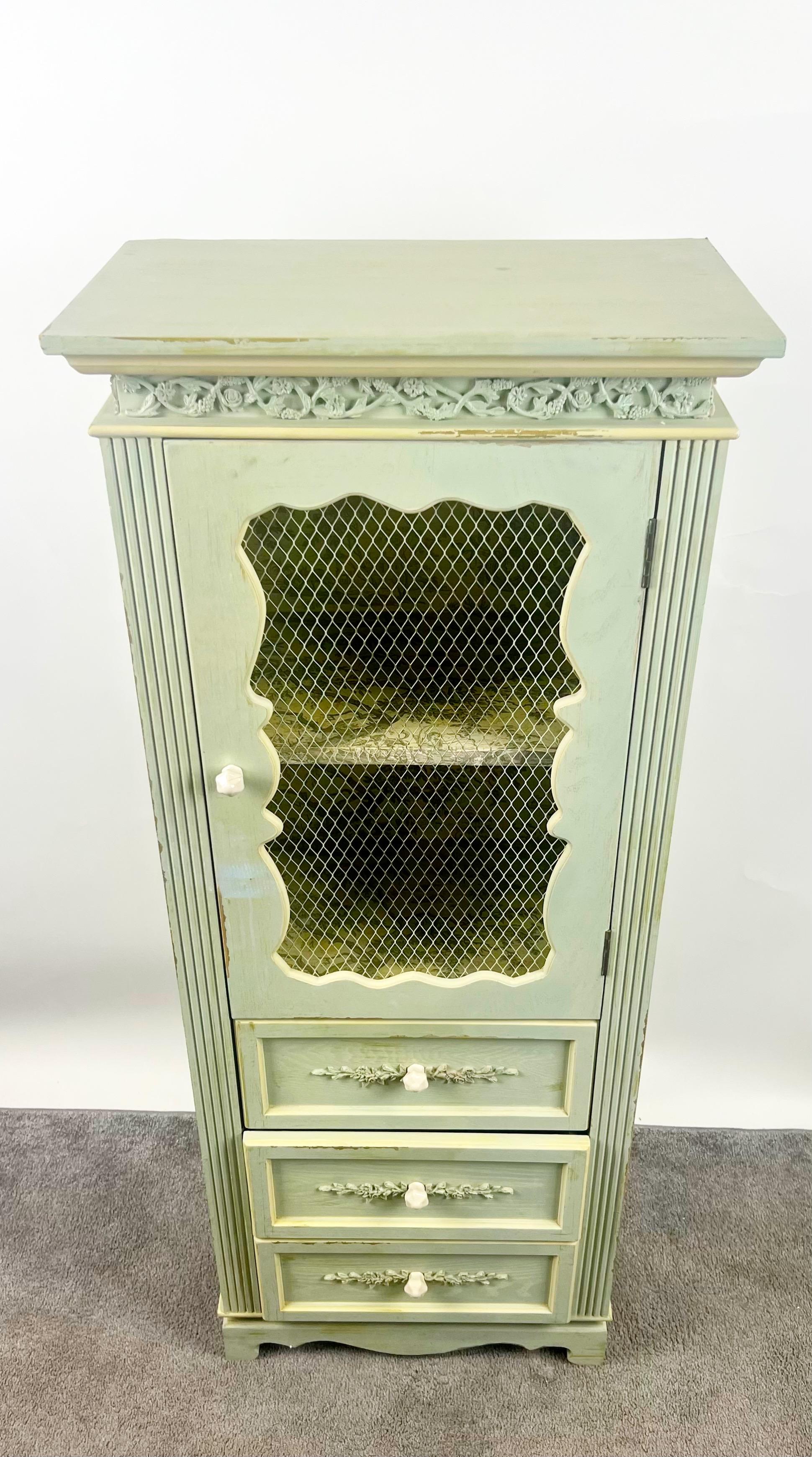 French Provincial Style Mid-Century Distressed Green Cabinet with Three Drawers: 

This charming French Provincial cabinet exudes rustic elegance and timeless sophistication. Hand-painted in a soft, muted celadon green with subtle distressing, the